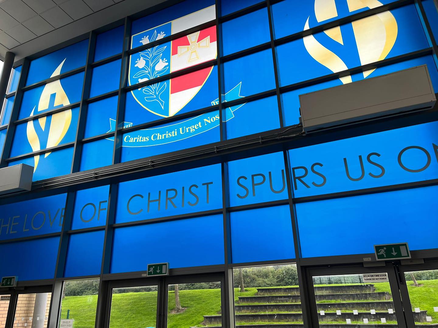 @st.josephscatholicacademy have the most amazing windows. But in being so beautiful and grand they were exposed to unwanted sunlight and glare often all year round.
This summer NE Display applied some printable window films to detract from the issue.
Working with the school to bring the school logo, moto and FLAME (Faith, Learning, Attitude, Mutual respect and Enrichment) together in this eye catching display.