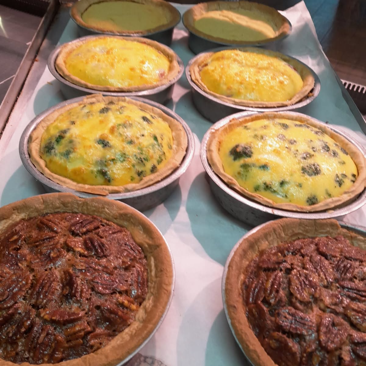 Some quiche and tarts fresh out of the oven and ready for today. 😋