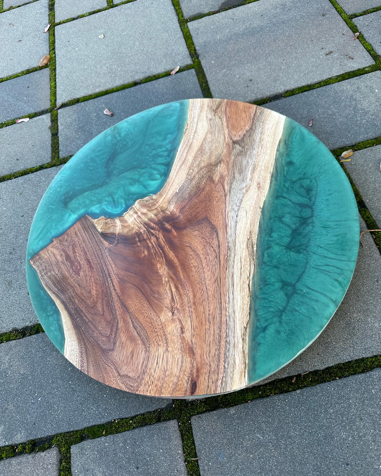 An 18 inch lazy Susan in black acacia and greenish resin with some black swirls.