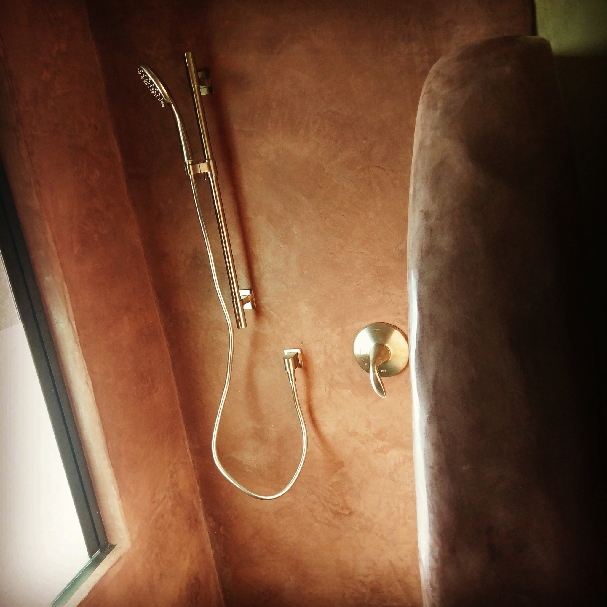 #tadelakt is a technique for compressing (burnishing) and sealing lime plaster. It was first developed in Morocco to line cisterns.
It works because of the chemistry...which is as follows:
1. Inert lime found in nature, chemically CaCO3 (calcium carbonate, limestone, marble, etc.) is heated → this creates CaO (quicklime, calcium oxide, highly reactive with water) + CO2 (which escapes into the atmosphere)
2. Water (H2O) is added to the calcium oxide (CaO) in a process called slaking → The result is chemically Ca(OH)2 (calcium hydroxide, which is reactive with carbon dioxide) + intense heat! This process requires a lot of safety gear. (Note that adding water to powdered Ca(OH)2 is re-hydration, not true slaking)
This is what is used to make plaster!
3. On the wall, the calcium hydroxide, chemically Ca(OH)2 re-absorbs CO2 from the air → becoming the exact thing you started with: CaCO3 (closing the carbon cycle and returning to calcium carbonate)
4. For tadelakt, there is one extra bit of chemistry, used to create an integral wax sealer in the surface of the lime. For this reaction, soap is applied in thin layers to the surface of the compressed lime. The unreacted calcium in the lime (Ca) and stearic acid in soap have a chemical reaction → creating calcium stearate (common waxy binder; basically really beautiful soap scum)
And TADA! You have a beautiful sheen and a water-repellent wall.