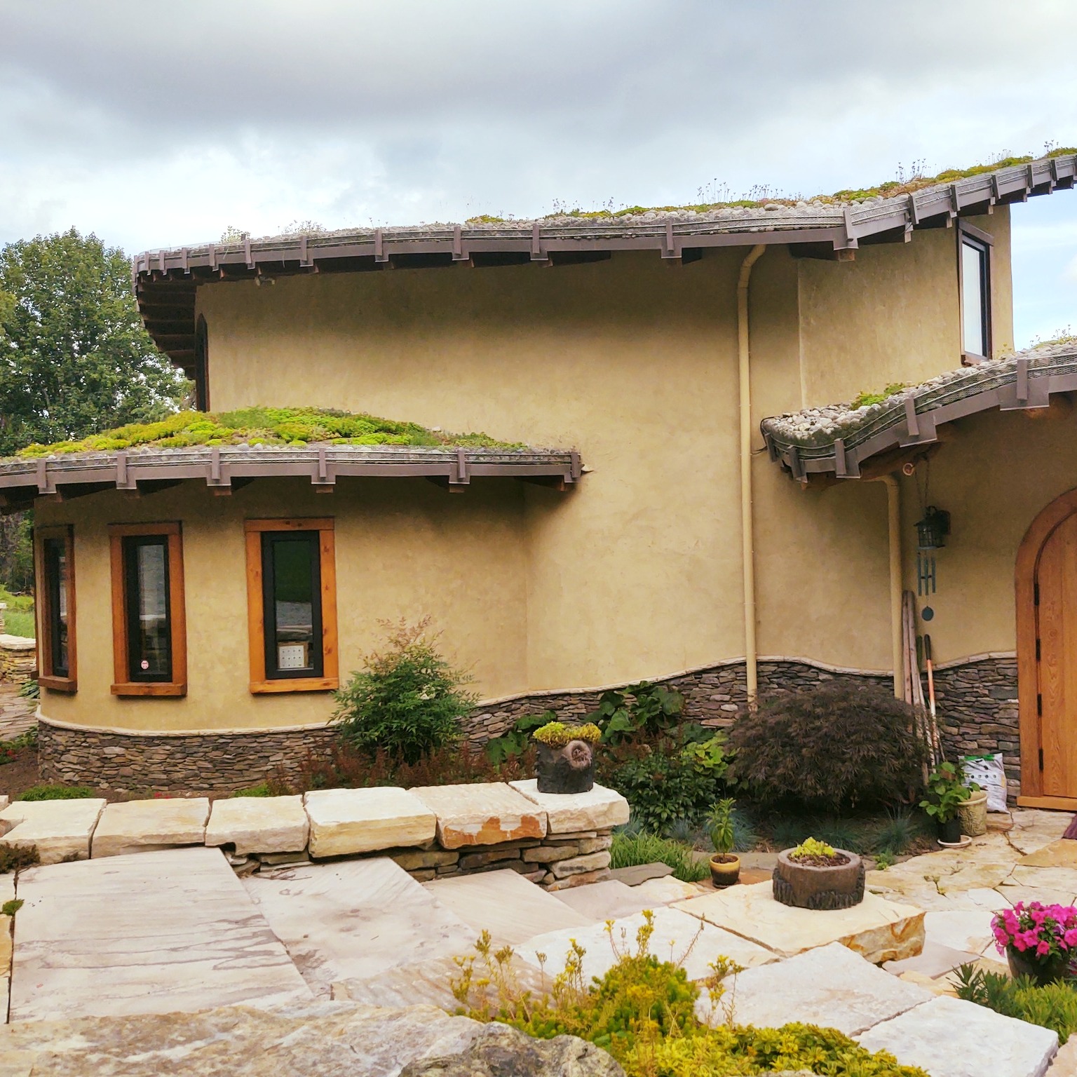 #strawbale homes offer exceptional #energyefficiency. When combined with direct #passivesolar strategies, you can reduce energy usage by 40%. If you do indirect passive solar (with a clay wall heated by the sun in winter), you can achieve achieve an 80% reduction...even in a semi-cloudy location. If you live somewhere that is sunny all winter, you can reduce the need for heating altogether!🤯
These photos show the construction process for finishing a strawbale home...in reverse order.
The method shown is called "infill strawbale" construction, which basically means you begin by building a frame, get the roof up and leak-proof. Then install strawbales around the frame. When strawbales are in, plaster goes on (or siding if you prefer). Plaster can be #limeplaster for a more durable, low-maintenance approach. Or can be thick #clayplaster if you have a low roof with deep overhangs and don't mind a the look of a little erosion.
The #strawbales provide the exceptionally high insulation. The thick plasters provide lots of mass to the inside and outside. Any additional clay elements you put inside the home, such as clay walls or clay floors, add even more thermal mass. And since thermal mass materials act like a battery for heat energy, insulation + interior mass = a home that stays comfy regardless of what mayhem is going on outside. #formulaforsuccess
#boom #naturalarchitecture #designlikeyougiveadamn #designlikeagirl #buildlikeagirl #paradigmshift