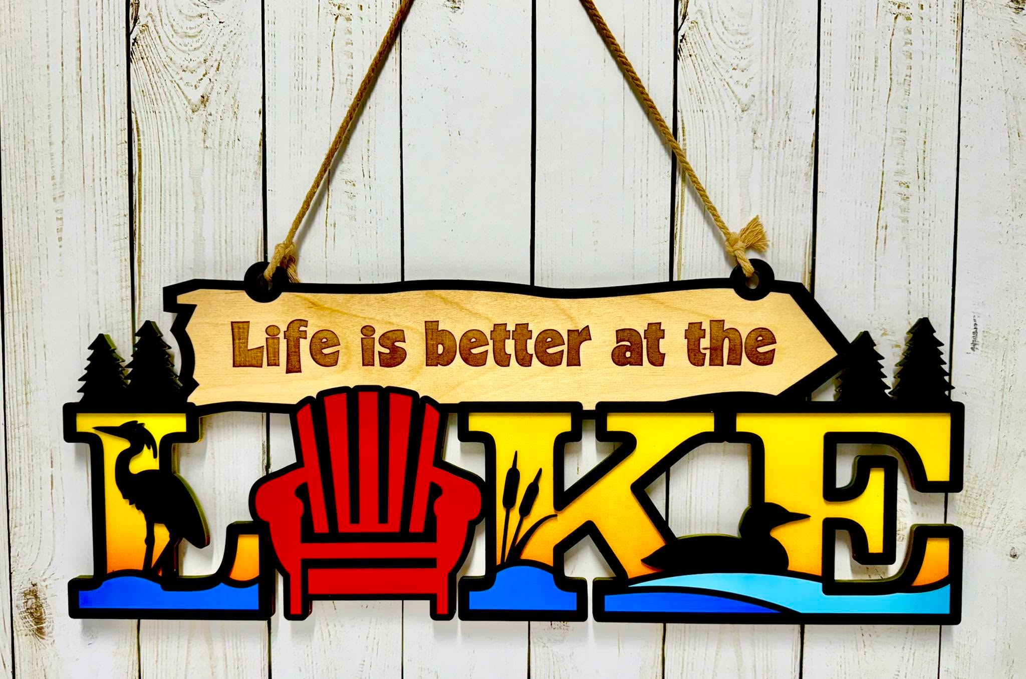 Colourful wooden layered “Life Is Better At The Lake” sign. Measures 20” x 8”. Message for more info.