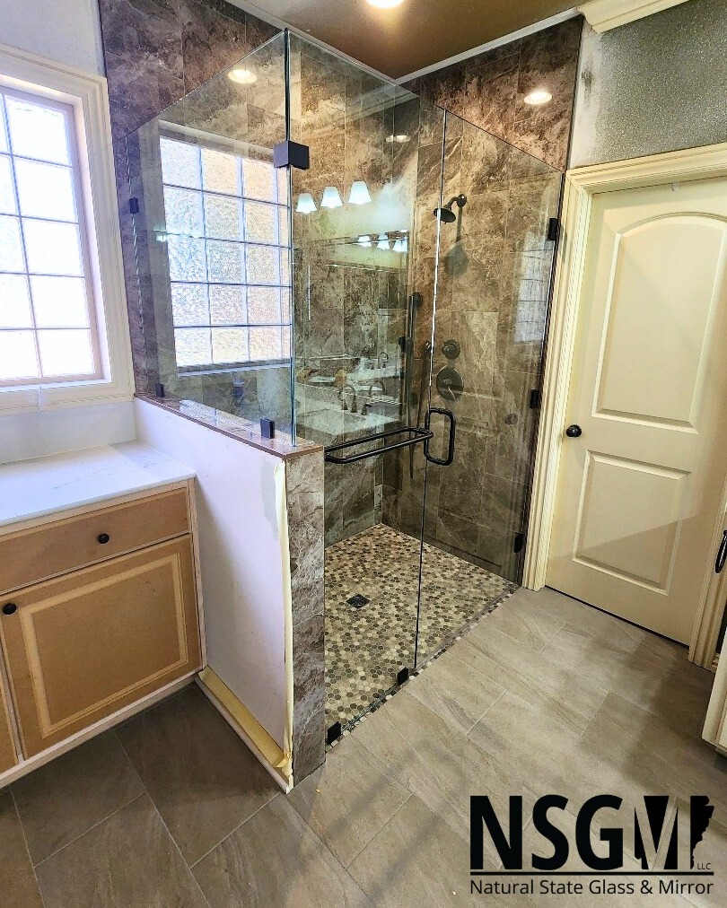This is a beautiful example of a frameless 90° enclosure with a pony wall. If you look at the panel beside the door you'll see what we call a back to back towel bar. These are beneficial if you are limited on wall space or want to keep a consistent aesthetic. You can put a towel on the outside and use the inside for a washcloth or two!
-
📞Call us at (479) 856-8500 to schedule your free estimate today!
🌐Visit us online by clicking the link in our bio!
📍Come see us in person! At 13293 Puppy Creek Rd Springdale, AR.
#FreeEstimates #nwarksmallbusiness #NSGM #naturalstate #naturalstateglassmirror #glass #NWA #customshower #showerdesign #springdalear #rogersar #bentonvillear #fayettevillear #lowellar #bellavistaar #bathroomdesign #interiordesign #luxurybathroom #nwabusiness #northwestarkansasbusiness #glasscompany #customglassshower #customglass #LuxuryShower #Arkansas #nwahomes #homeimprovement #nwarkansas #glass #framelessshower
