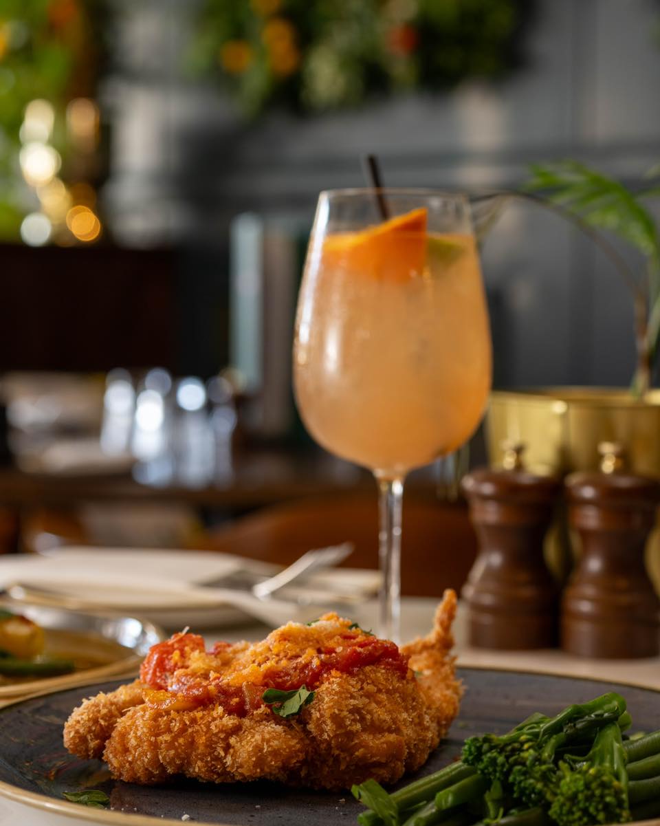 Indulge in flavor at MAK Restaurant – crispy Panko chicken breast crowned with zesty tomato and pepper sauce, finished with a Parmesan sprinkle.