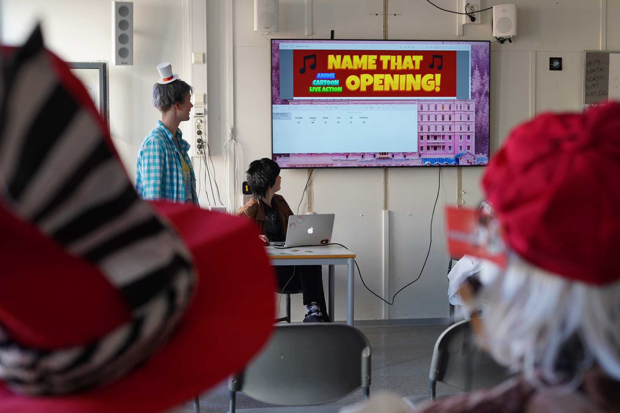 Dere har vært med å gjette tv-showåpninger på forrige Kazu og på Constellation, men hvor godt klarer dere å kjenne igjen musikaler? På søndag får dere muligheten til å teste evnene deres!!
I samme stil som Name That Opening!, men tilpasset årets tema, kommer Vilde og Ylva til å spille av sanger fra ulike scene-, film- og rene audiomusikaler. Det er opp til deltagere fra publikum å være først til å gjette hvilken musikal hver sang er fra!
Klarer du å kjenne igjen favorittmusikalen din før alle de andre, og ta ledelsen i å synge ferdig refrenget? Hva er den mest obskure musikalen du har hørt om? (Visste du at Phantom of the Opera har en oppfølger?)
Kom og finn ut på Name That Musical!