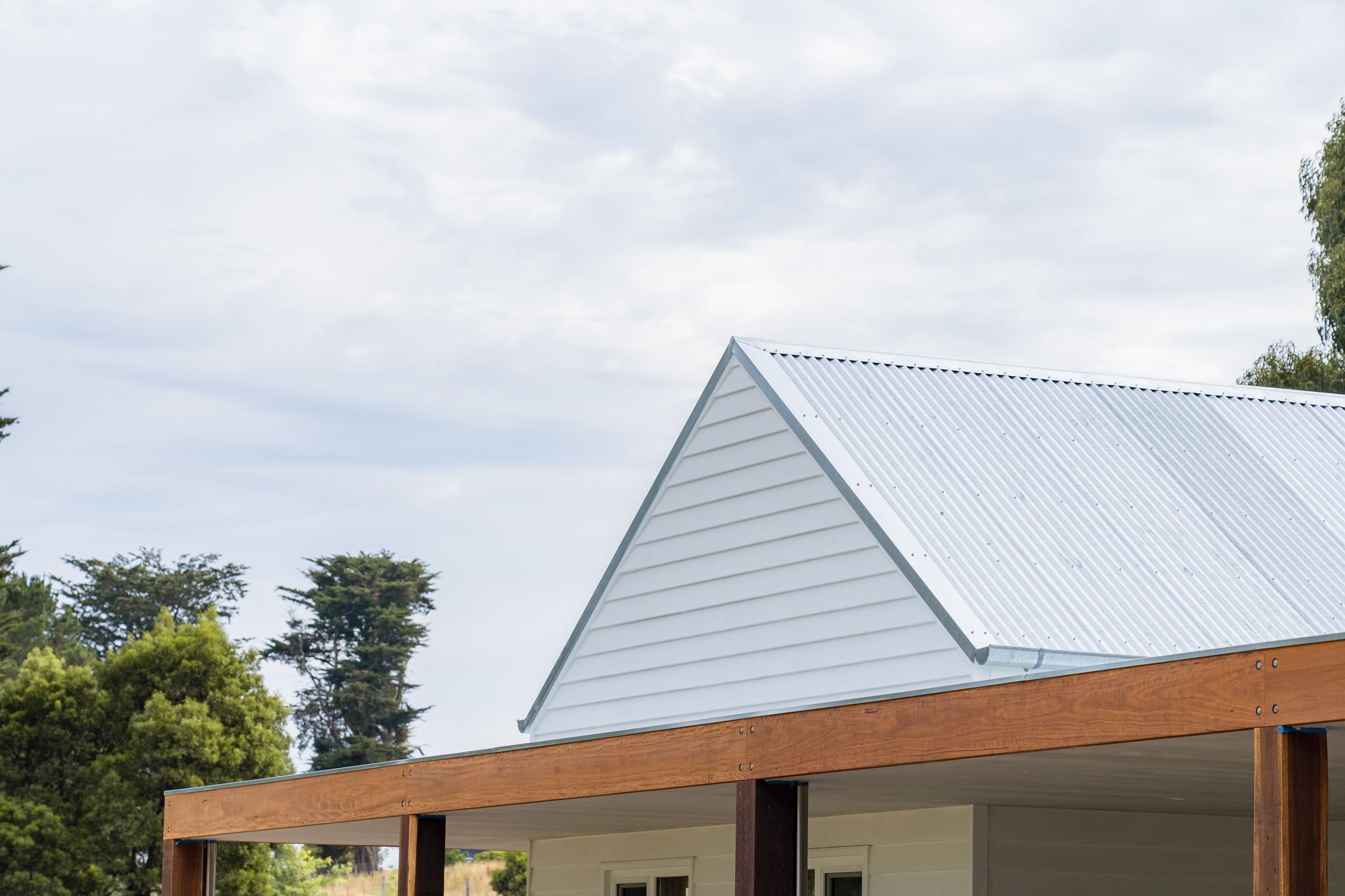 Explore this stunning flat roof verandah, enhanced by a 35-degree pitch gable end and featuring heritage galvanised steel corrugated roofing!
Heritage-grade galvanised steel typically possesses a thicker zinc coating compared to standard galvanised steel, providing superior corrosion resistance. This quality is particularly beneficial in coastal or high-moisture environments, resulting in an extended lifespan.
Verandah and James Hardie Weatherboard installation by @j.hirst_constructions
Roofing by us @promacplumbing.roofing
Photography by @kgmgcreative
#Verandah #FlatRoof #GableEnd #HeritageDesign #GalvanisedSteel #Roofing #HomeImprovement #OutdoorLiving #Construction #JamesHardie #Weatherboard #CoastalLiving #CorrosionResistance #BuildingDesign #ArchitecturalDesign #SustainableBuilding #HomeRenovation #ModernArchitecture #OutdoorSpaces #DesignInspiration