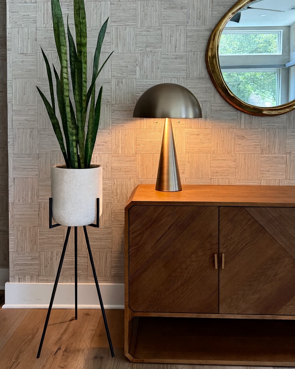 ✨ It’s all in the details. ✨ The natural woven grasscloth wallcovering from @thibaut_1886 brings subtle depth and dimension to this corner, making the warm wood tones and brass accents pop. A reminder that sometimes the quietest design choices make the loudest statement.