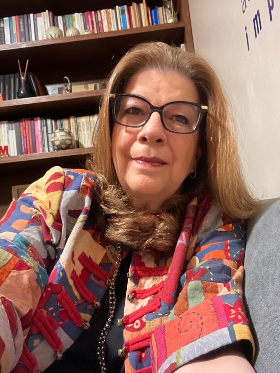 Escolher uma roupa é, desde a minha infância, uma das memórias mais afetivas que tenho da minha mãe. Ela tinha prazer em procurar o que considerava belo para vestir. Gostava de vitrines, aguardava revistas com os novos modelos e tendências, escolhia com prazer tecidos e aviamentos para levar à costureira. Ainda que gostasse de qualidade e admirasse a alta-costura, não eram exatamente as marcas famosas o que a atraía, era o belo. O que ela achava bonito.
Apresentava-se sempre com cuidado, com esmero, e entendia isso como parte da dignidade. Através das roupas e adereços cochichava sobre o feminino.
A moda era a parte mais prosaica do seu amor pela arte, especialmente o cinema; mas também o teatro, a música e a literatura. Foi por suas mãos que adentrei nesse mundo e também dei os primeiros passos na Psicanálise.
Um dos nossos últimos momentos de maior prazer foi quando escolhemos sua roupa para o aniversário de 80 anos. Voltei à infância, na posição invertida. Ela já estava doente, mas naquele momento, a alegria dela diante do espelho, virando-se de um lado para o outro e se vislumbrando bonita para sua noite, escreveu em mim um texto inteiro de recordações.
Quando ela se foi, seu armário parecia um enorme baú de lembranças. Minha mãe era colorida. Escolhi algumas peças, não muitas. Nem tudo que lhe caía bem se parecia comigo.
Há poucos dias, vesti esse casaco. Seus braços me envolveram com delicadeza e os pequenos guizos me trouxeram seu riso. Naquele instante entendi que, às vezes, a saudade é colorida.
#elizamacielpsicanalise #psicanaliseclinica #psicanalista #autoconhecimentotransforma #casaco #mãe