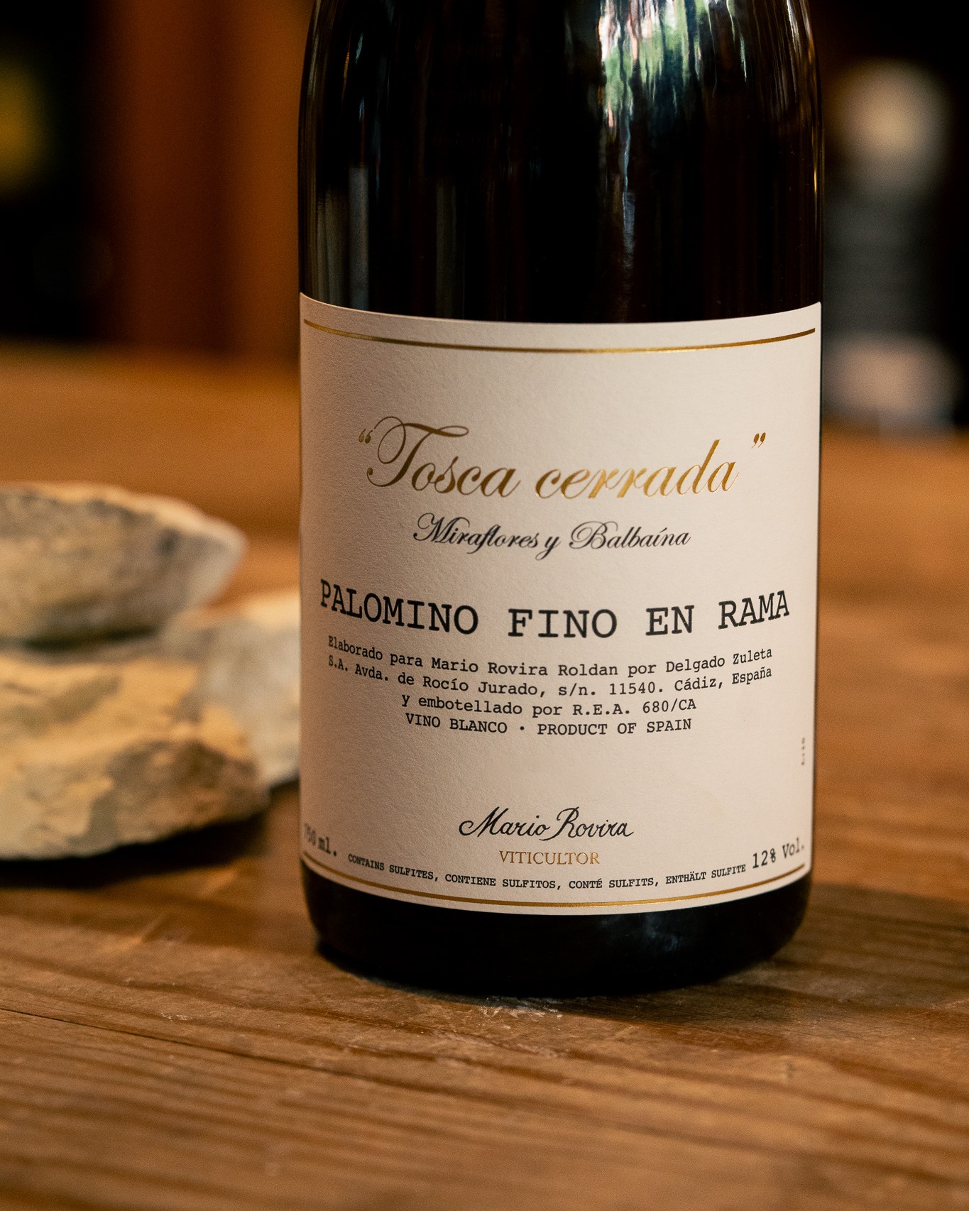 Este otoño recibiremos en Tierra la nueva añada 2024 de Tosca Cerrada, uno de los vinos más singulares de Mario Rovira dentro de su proyecto en el Marco de Jerez, creado en 2014 junto a Bodega Delgado Zuleta.
El viñedo, de cultivo orgánico, se encuentra cerca de Jerez y Sanlúcar de Barrameda, en una zona con fuerte influencia atlántica. Este clima, dominado por la interacción de las brisas frescas y húmedas del océano y el viento cálido y seco de Levante, permite la formación natural de la flor, una levadura superficial que protege el vino de la oxidación y le confiere aromas únicos.
Tras una vendimia manual, el mosto se extrae por gravedad y fermenta de forma espontánea en depósitos de hormigón. La crianza se realiza bajo flor, en tanques de acero inoxidable o en barricas usadas de manzanilla, dependiendo del estilo buscado. Finalmente, el vino se embotella en rama, es decir, sin filtrado, clarificación ni sulfitos añadidos.
El nombre Tosca Cerrada hace referencia a un tipo especial de albariza, un suelo blanco y compacto que retiene la humedad en un clima cálido y seco. Esta estructura obliga a las raíces de la vid a profundizar, aportando concentración y una marcada identidad a la uva. El resultado es un vino Palomino Fino sin fortificar, puro y expresivo.
Encuéntralo en nuestra distribuidora y vinotecas este otoño 🍁