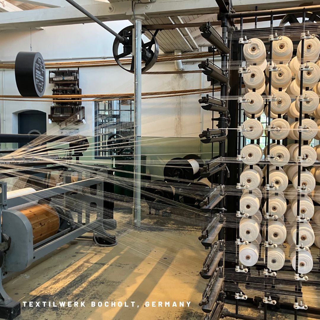 Tkalcovské sály v @textilwerkbocholt jsou jako časová kapsle – cítíš se jako v jiném světě i století. Na obrázku je vidět natažení osnovy do jednoho z mnoha jejich tkalcovských stavů. #textilehistory #purplyworkshop
---
The weaving halls at @textilwerkbocholt are like a time capsule – you feel like you’re in another world and century. The picture shows the warp being drawn into one of their many looms. #textilehistory #purplyworkshop