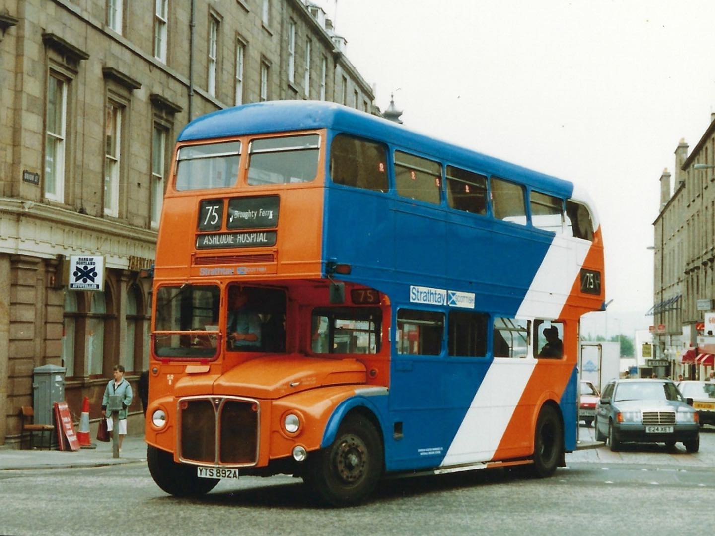 🚌❤️ This week’s Feature Friday takes us back to the colourful days of Strathtay Scottish with this striking double decker, bus number 75, bound for Ashludie Hospital!
Painted in the company’s bold orange, white, and blue livery, this bus was a familiar sight across Dundee and Broughty Ferry during the late 1980s and early 1990s. Its vibrant design made it stand out from the more traditional tones of earlier Dundee fleets, marking a new era of local transport.
A fantastic snapshot of everyday life on the city’s streets – and another brilliant piece preserved in our collection!