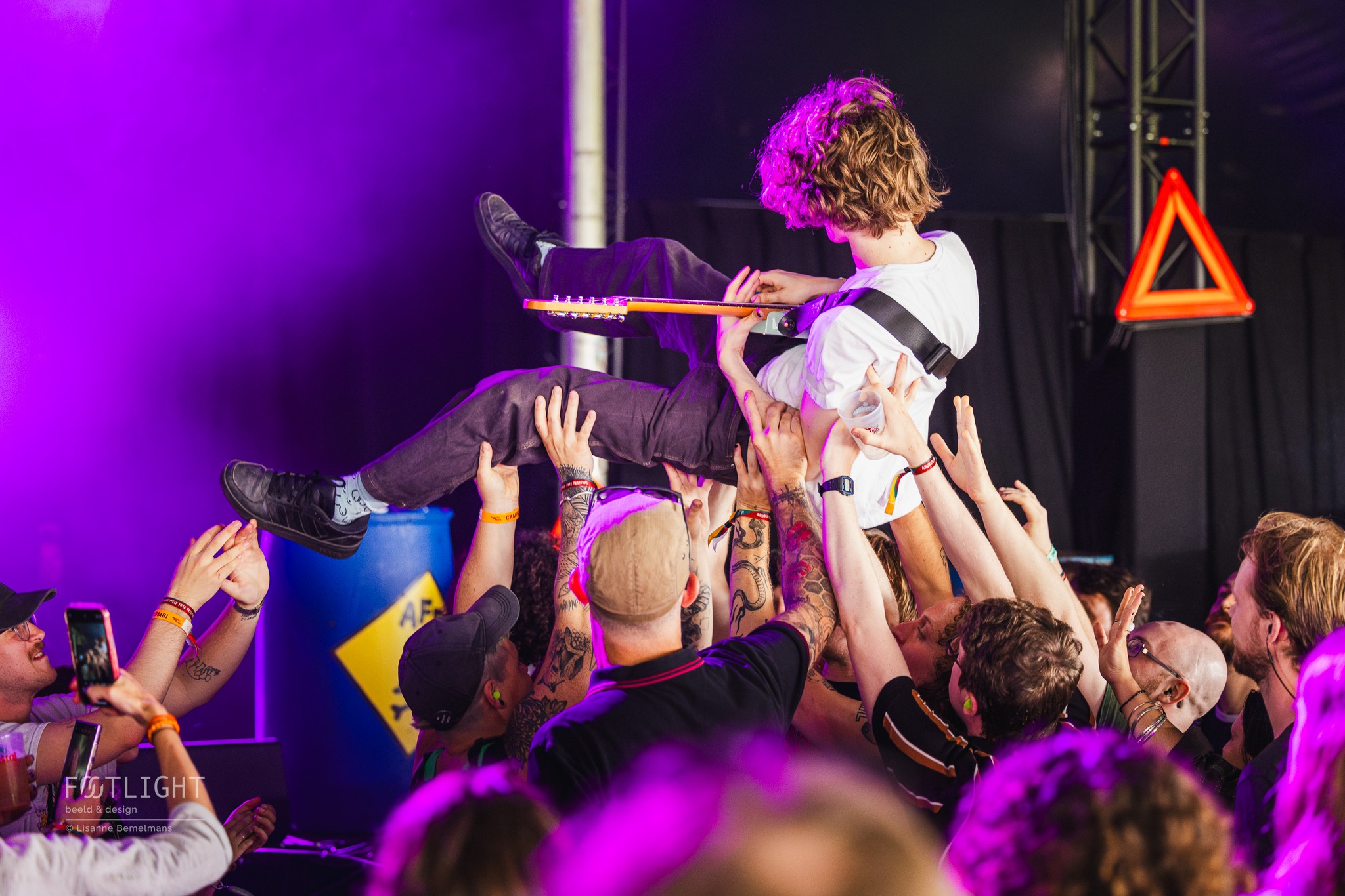 Neem je fans mee in je muzikale wereld, vanaf het eerste akkoord tot de laatste uitsmijter.
Je setlist staat niet zomaar op papier; hij is gebouwd op flow, energie en balans. Elk nummer is bewust gekozen om het publiek precies te geven wat ze nodig hebben.
Het licht danst mee.
De gitarist springt ritmisch op en neer.
De leadzanger grijpt de microfoon zó stevig vast.
Alles leeft. Alles beweegt.
En dan dat ene moment…
De zanger zoekt oogcontact, ademt diep in en zegt:
“We hebben er nog eentje voor jullie, op deze fantastische avond…”
Het sluitstuk. Het hoogtepunt. Het moment dat je voor altijd wilt vasthouden.
Ik vang die momenten waarin artiesten écht stralen, voordat ze verdwijnen in de tijd of in de repetitieruimte voor het volgende album. Ik leg vluchtige blikken, krachtige poses en de connectie met het publiek vast, zodat je later niet alleen kunt terugkijken, maar opnieuw kunt voelen hoe het was. Op die ene speciale avond.
Mijn foto’s zijn meer dan herinneringen.
Het zijn verhalen. Identiteit. Een blik op wat er écht gebeurde onder het licht en binnen de energie van jouw muziek.
Ik fotografeer muzikanten, omdat live muziek voor mij het meest pure verhaal is dat je kunt vertellen.
Alles gebeurt echt. Niets is gespeeld. Elk moment kan de magie zijn die jouw avond, je show of je publiek raakt.
Ik voel het wanneer een artiest openbreekt op het podium, in energie, licht en emotie. Dát wil ik vangen. Niet alleen om het mooi vast te leggen, maar zodat jij iets in handen hebt dat laat zien wie je bent, waar je voor staat, en wat je muziek doet met mensen.
Dat is mijn drive.
Daarom werk ik naar de fotopit toe.
Daarom fotografeer ik.