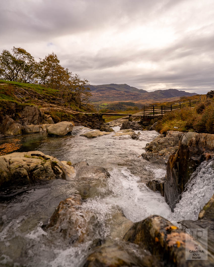 Weekly Prime – Week 12 | 20mm Prime
Sony A7III | FE 20mm f1.8 G | f3.2 | ISO 100 | 20mm
Location: Watkins Path, Snowdon
I took the 20mm out on the Watkins Path and worked along the river that runs beside the trail. The light was flat all afternoon so I tried exposure bracketing and blended the files later. The sky finally held some detail and the foreground water came through well once everything lined up. I like this one because it reminds me why that lens stays in my bag. It pulls you into the scene without feeling stretched and it lets you work close to the water without losing the wider story.
It was a good chance to slow down, get my feet in the rocks, and try something a little more deliberate.
If you were shooting this spot, what would you have done differently?
#ImACameraGuyNow #OneMistakeAtATime #WeeklyPrime #SonyA7III #Sony20mm #PrimeLensPhotography #LandscapePhotographyUK #SnowdoniaPhotography #WalesExplored #LearningPhotography #PhotographyPractice #ChaplainAndCo