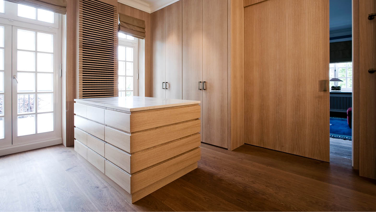 Die großflächigen Eichenfronten auf allen Schrankelementen, Wand- und Heizkörperverkleidungen sowie Türelementen sorgen für eine wunderbar aufgeräumte Atmosphäre. Die Schiebetür mit gedämpfter Einzugstechnik sorgt für komfortable Handhabung, während die integrierte LED-Technik die innere Trägerplatte in blauem Buntlack stimmungsvoll beleuchtet.
#ankleidezimmer #moebeldesign #wohnideen #innenausbau #holzhochzwei #tischlerhandwerk