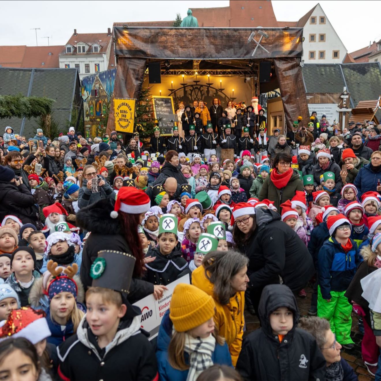 Heute war ein ganz besonderer Tag in unserer Silberstadt: Gemeinsam mit 270 Kita-Kindern haben wir den 34. Christmarkt feierlich eröffnet. 🤶👧🏼👦🏻
🎅🏻🎄Mit dem Märchenzug begann am Nachmittag der erste fröhliche Christmarkttag offiziell. Zusammen mit den Kindern, Weihnachtsmann, Engel, und Mitgliedern der Freiberger Berg- und Hüttenknappschaft – begleitet vom Freiberger Stadtgebläse zogen wir auf den Obermarkt.
Vor der Bühne sangen die Kinder nach einer schönen Moderation von Gerd Edler „Oh Tannenbaum“ und zeigten beim traditionellen „Baumanzünden“ und „Pyramideanschieben“ vollen Einsatz. Drei Mal tief Luft geholt und schon drehte sich die große Pyramide. Auch der schöne Weihnachtsbaum trägt ab heute sein Lichterkleid und die bergmännisch dekorierten Hütten sind bis zum 22. Dezember täglich geöffnet. ⚒️✨
👨👩👧 Familienfreundlichkeit bleibt ein Herzstück unseres Christmarktes: Neben dem Besuch des Weihnachtsmanns gibt es ein klasse Programm für Jung und Alt. Vor allem die Kleine Bergwerkstatt im Bauch des Rathauses ist ein wichtiges Element. Dort können Kinder basteln und kreativ werden, während viele Geschenkideen auf ihre Entdecker warten. Seit 19 Jahren wird sie liebevoll von zahlreichen ehrenamtlichen Helferinnen und Helfern organisiert. Das ist großartig!
🎄 In den kommenden 28 Tagen warten viele Höhepunkte auf euch: Schon am kommenden Sonntag steht das traditionelle Riesenstollenanschneiden an – ein Genussmoment für alle Stollenfreunde und eine schöne Tradition.👨🍳 Gleichzeitig lädt die Stadt zum verkaufsoffenen Sonntag ein: gemütlich bummeln, Geschenke shoppen und die Innenstadt erleben. Und obendrein gibt es wieder die beliebte Aktion an der Silberstadt-Baude: Zwischen 15 und 17 Uhr erhält jeder mit einem Kassenzettel über mindestens 20 Euro Einkaufswert einen Glühwein oder Kinderpunsch gratis.
Ich wünsche uns eine besinnliche, friedliche Adventszeit und lade alle ein unseren Markt bewusst zu genießen und die Gemeinschaft in Familie, mit Freunden oder mit Kollegen zu erleben.
📸: Marcel Schlenkrich | Silberstadt Freiberg (1-3)