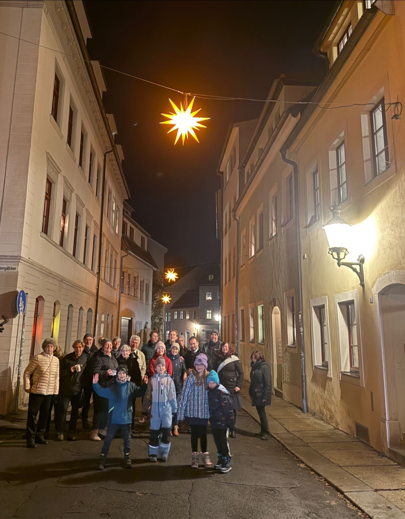 ✨Dank der Initiative engagierter Anwohner leuchten nun bereits im fünften Jahr sieben Sterne über der Moritzstraße und dem Domgäßchen. Inspiriert wurden Sie bei den Eigentümern der Pfarrgasse, die den Himmel ihrer Gasse schon seit vielen Jahren mit Sternen erleuchten – dafür ein herzliches Dankeschön!
Gestern bin ich mit den Anwohnern zusammengekommen. Wir haben bei Glühwein, Punsch und etwas weihnachtlichem Gebäck die Sterne „angezündet“ und mit guten Gesprächen eine schöne Zeit verbracht und uns gemeinsam an den leuchtenden Sternen erfreut – eine richtig schöne Einstimmung auf die Adventszeit.
Schon bald soll auch die Kirchgasse mit Sternen geschmückt werden und so eine weitere Gasse der Altstadt im Sternenglanz erstrahlen. Neben unserer eigenen Weihnachtsbeleuchtung wird damit unsere Silberstadt Freiberg in der Adventszeit noch stimmungsvoller und festlicher.💫✨
Ich freue mich sehr über dieses nachbarschaftliche Engagement! 🌟