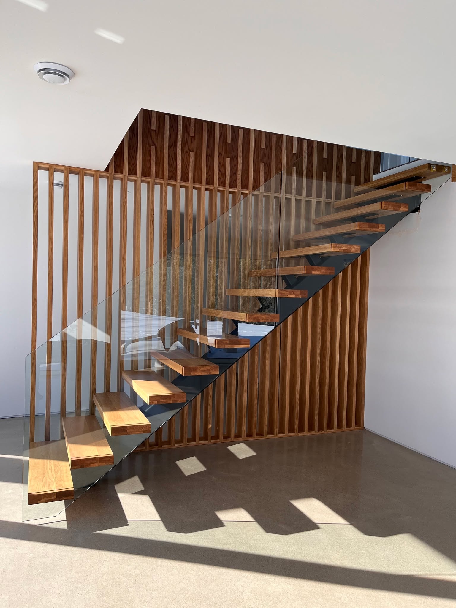 Floating on purpose. ✨
This completely custom stair was designed and built to feel light in the space while still reading as a strong architectural feature. Warm wood treads, a crisp black steel stringer, and a seamless glass guard keep sightlines open, while the slatted wood wall adds rhythm and texture from every angle. Clean, modern, and made-to-measure for the way this home moves.
Modern Arc crafted a custom floating staircase with wood treads, black steel structure, and a frameless glass railing an elevated modern feature that blends precision detailing with warm, minimal design.
#CustomStaircase #FloatingStairs #ModernStaircase #GlassRailing #ArchitecturalMillwork #ModernArc #ContemporaryDesign