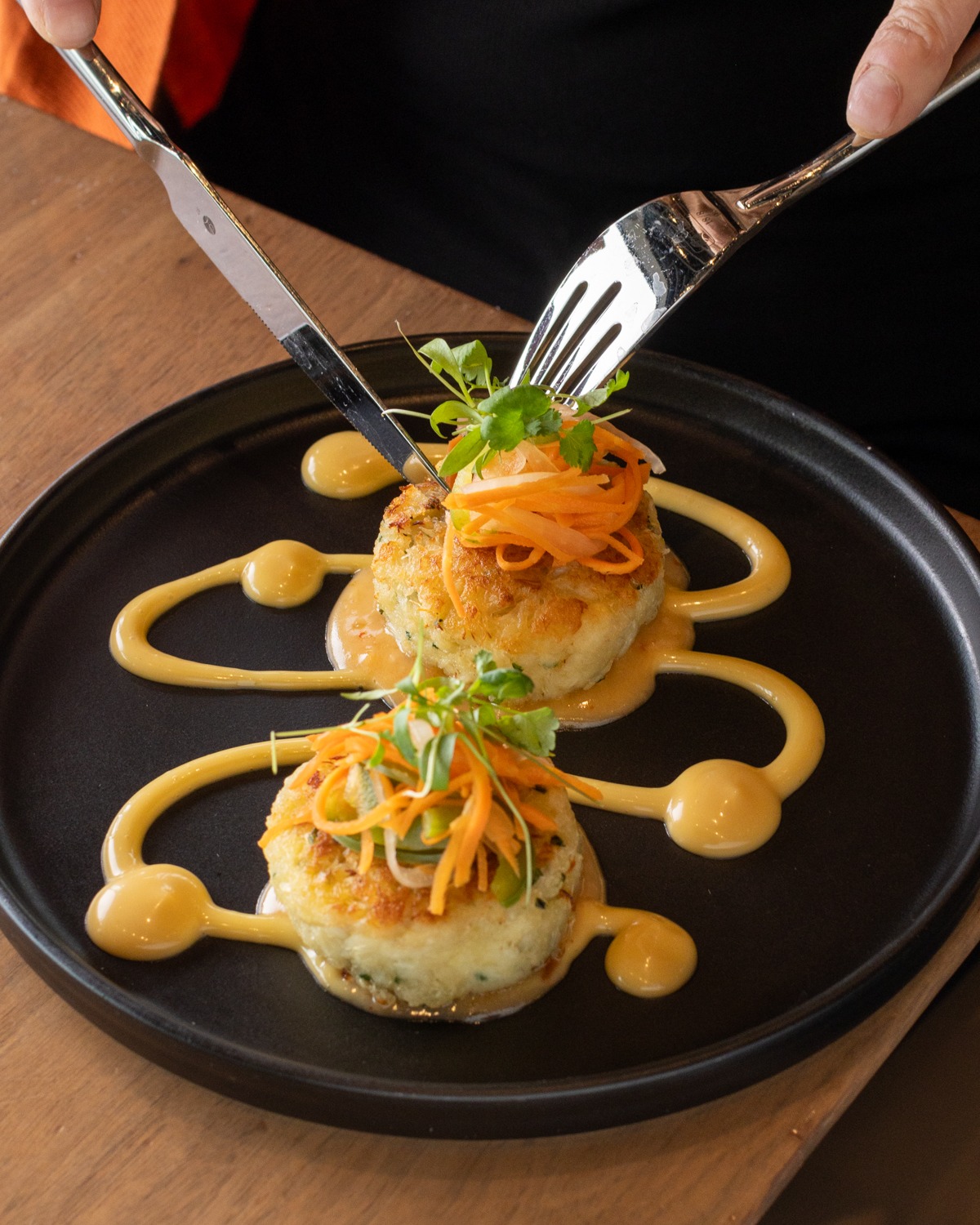 Cold outside, cozy inside ✨
Settle in and share something special with the people you love!
Our Lump Blue Crab Cakes are perfect for the table, finished with sesame-orange aioli, sweet & sour beurre blanc, pickled jalapeños, and micro cilantro.
Join us and make it a night worth lingering over 💛