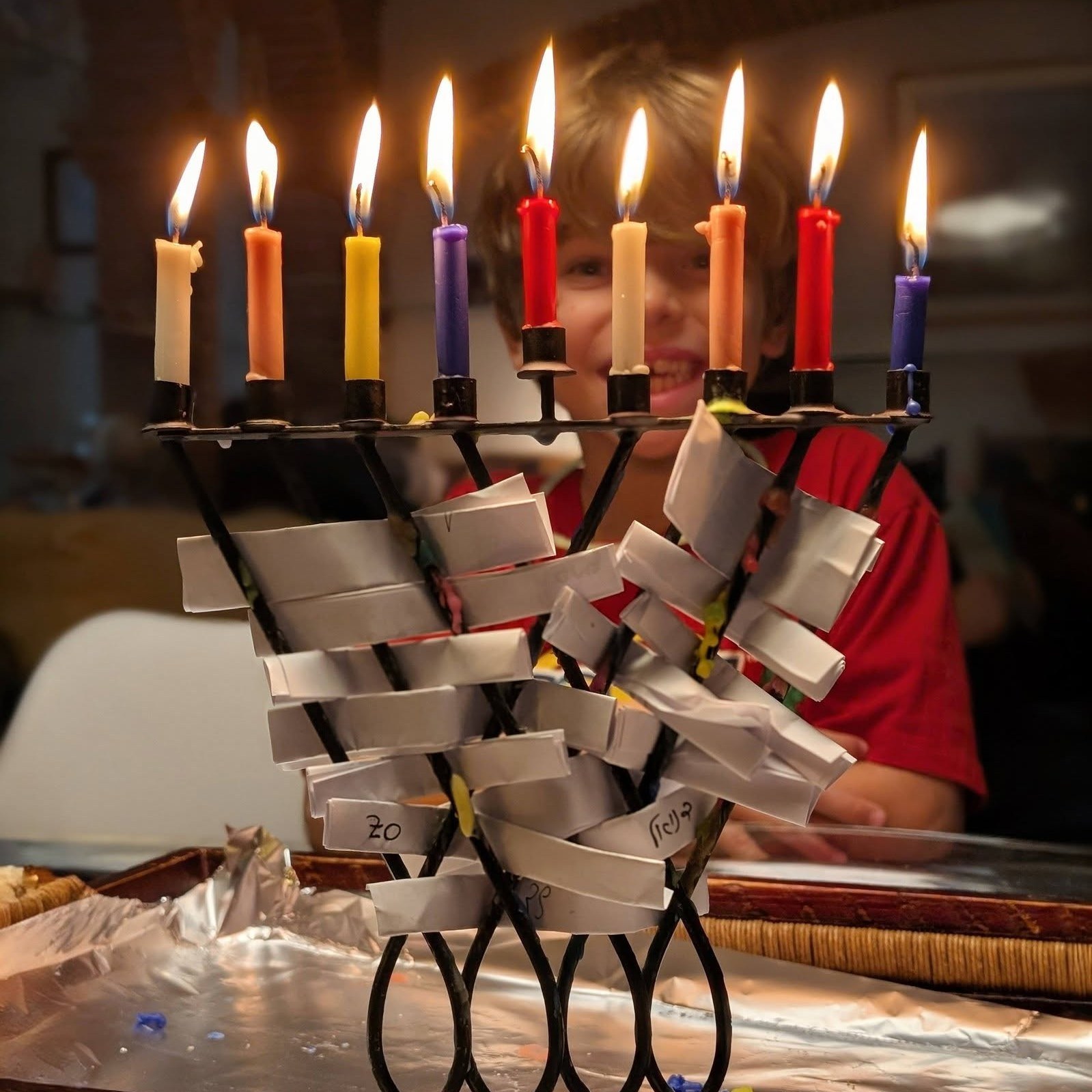 There is one moment during Hanukkah that I wait for all year, it happens right in the middle of the last evening.
After we light all eight candles and sing the songs, when the flames are already dancing and the house is filled with warm light, but before we eat the sufganiyot.
In that moment, we pause.
Everything is still open, still possible, not yet scattered. There is a kind of quiet that makes room for real thought. Each of us takes a small piece of paper and writes down one wish for the year ahead. Not a list. Not a plan. Just one wish. Something we want to happen.
After everyone finishes writing, we fold the notes carefully and slide them between the branches of the Hanukkiah. We let the candles keep burning, let the light stay a little longer, let the evening simply be. Only when the candle flames finally go out do we place the Hanukkiah, with all the wishes still inside, into the cupboard. There it waits for a full year, quietly, without reminders or notifications, until the next Hanukkah.
It’s easy to see this as a sweet, almost innocent tradition. A kind of family version of New Year’s resolutions. But over the years, I’ve realized there is something much deeper here, and more importantly, something very practical.
Our wishes don’t sound like prayers for miracles. They sound more like quiet declarations of intent. There is direction in them. There is a sense of time. And most of all, there is responsibility.
The moment those three things come together, intention, a time frame, and the act of writing it down in your own words, something starts to move. A kind of internal compass is created. Knowing that in a year I will open that note means that, slowly, some of my choices, consciously or not, begin to align in that direction.
Dreams don’t happen on their own. They need more than desire. They need intention, time, and a conscious decision to take ownership of them. That’s what the wish inside the Hanukkiah is doing. It’s a small moment where we allow ourselves to admit what we truly want, and give it permission to start working in the background.
Do you have a dream? Maybe it’s time to give it that push...
.
#IntentionalLiving #DreamsInMotion