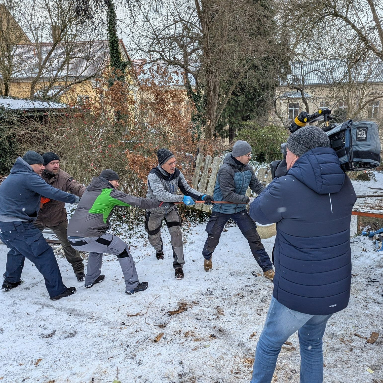 Abrissparty 1.0:
Liebes Tagebuch,
heute war so ein Tag, wo Erwachsene wieder ganz schlimme Kinder waren.
Eigentlich hieß es Spatenstich , aber ehrlich gesagt war es eher harmonisches Brechstangenschwingen und dabei glücklich glotzen. Und das bei Wohlfühltemperaturen unter der Gürtellinie – Nase kalt, Hände kalt, Hirn kurz eingefroren. Trotzdem: Geiler kann ein Neujahrsanfang nicht sein!
Vor uns: eine Bruchbude, hinter uns: der ganze Vereinshaufen und mittendrin ganz viel Chaos. Zur Rettung kam Rico mit seiner bomforzionösen
Pizzasuppe.
Dann wurde es wild: Mit einem Seil wurde der Schuppen bearbeitet, bis er endlich verstanden hat, dass er hier nicht mehr wohnen darf. Zack, weg! Und die Männer? Kurz mal umgefallen muahaha. Svenni guckte kurz mal verdutzt aus seinem imaginären Bilderrahmen wie die Mona Lisa. Danach alles schön in kleine Häufchen kaputtgemacht.
Überall flog Putz von den Wänden,, Michi und Steve sahen irgendwann aus wie zwei wandelnde Schneemänner, während unsere fleißigen Kinderhelfer mit vollem Körpereinsatz die zukünftige Werkstatt aus buddelten, als gäbe es dort einen Schatz und waren dabei ungefähr tausendmal motivierter als alle Erwachsenen zusammen. Lars und Jörg spielten währenddessen Müllmänner Deluxe und haben den ganzen Schrott fröhlich in der Oberlausitz verteilt (natürlich ordnungsgemäß!).
Und dann noch unser Highlight: Das Fernsehen war da – MDR Sachsenspiegel! Die wollten mal gucken, was wir hier treiben, und es der ganzen Welt zeigen. Also haben wir besonders professionell ausgesehen (also ungefähr) und extra viel mit Werkzeug gewackelt.
Am Ende waren alle dreckig, müde, kalt – aber mega glücklich.
Ich freu mich jetzt schon wie ein Flummi auf die nächste Aktion.
Ende des Eintrags. Ich geh jetzt auftauen.
www.lichtspielhof-loebau.de/vereinshaus