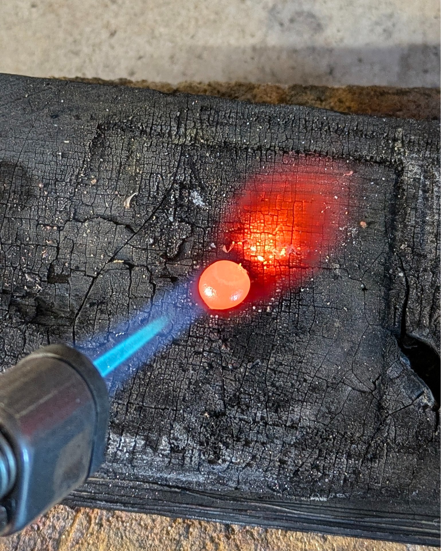 This is going to be a very common sight on my workbench from now on. The cost of silver is just so high that I'm going to be recycling as much as I can. This little ball of molten silver will be flattened and used to make some little flowers that I need for a design.
It's a process that I quite enjoy and love this stage when it looks like a little comet flying through space with the red tail behind it.