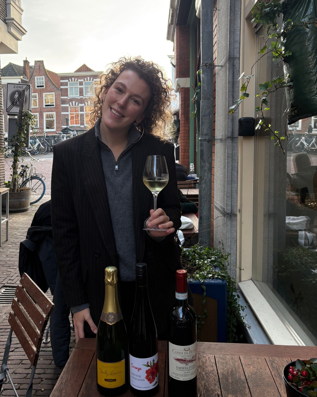 De favoriet van... Eva🍷
Eva is een echte horecatijger met een passie voor mooie wijnen en dat terwijl ze óók nog rechten studeert! Altijd enthousiast, altijd vrolijk en altijd klaar om haar liefde voor wijn te delen met iedereen om haar heen. Deze drie wijnen mogen niet ontbreken in haar favorietenlijst:
🍾 Crémant de Bourgogne Réserve Brut
Een elegante mousserende wijn uit de Bourgogne, gemaakt volgens de traditionele methode. In de neus frisse appel, peer en een subtiele briochetoon. In de smaak levendig, strak en mooi in balans met een fijne mousse. Perfect als aperitief, maar ook verrassend goed inzetbaar aan tafel bij vis, schaal- en schelpdieren of lichte voorgerechten. Een stijlvol alternatief voor champagne.
🍊 Winzer Krems ‘Bee Orange’ Grüner Veltliner
Een orange wine met karakter, gemaakt van Grüner Veltliner die langere tijd op de schillen vergist. Dat proef je: meer structuur, lichte tannines en een kruidige, bijna thee-achtige complexiteit. Aroma’s van gedroogde citrus, appel, kruiden en een vleugje honing. Ideaal voor de avontuurlijke drinker en perfect bij vegetarische gerechten, paddenstoelen, geroosterde groenten of kazen met wat pit.
🍷 Costa di Bussia Barbera d’Alba
Een klassieke Barbera uit Piemonte, bekend om zijn sappigheid en frisse zuren. Veel rood fruit zoals kers en framboos, aangevuld met een lichte kruidigheid. Zacht in tannines, maar vol van smaak, waardoor hij ontzettend doordrinkbaar is. Een echte tafelwijn die het geweldig doet bij pasta’s, charcuterie, óf gewoon voor een lange avond tafelen.
Heb jij deze al geproefd? Of wil je weten waarom Eva juist deze koos? Kom langs of vraag haar ernaar! 🥂