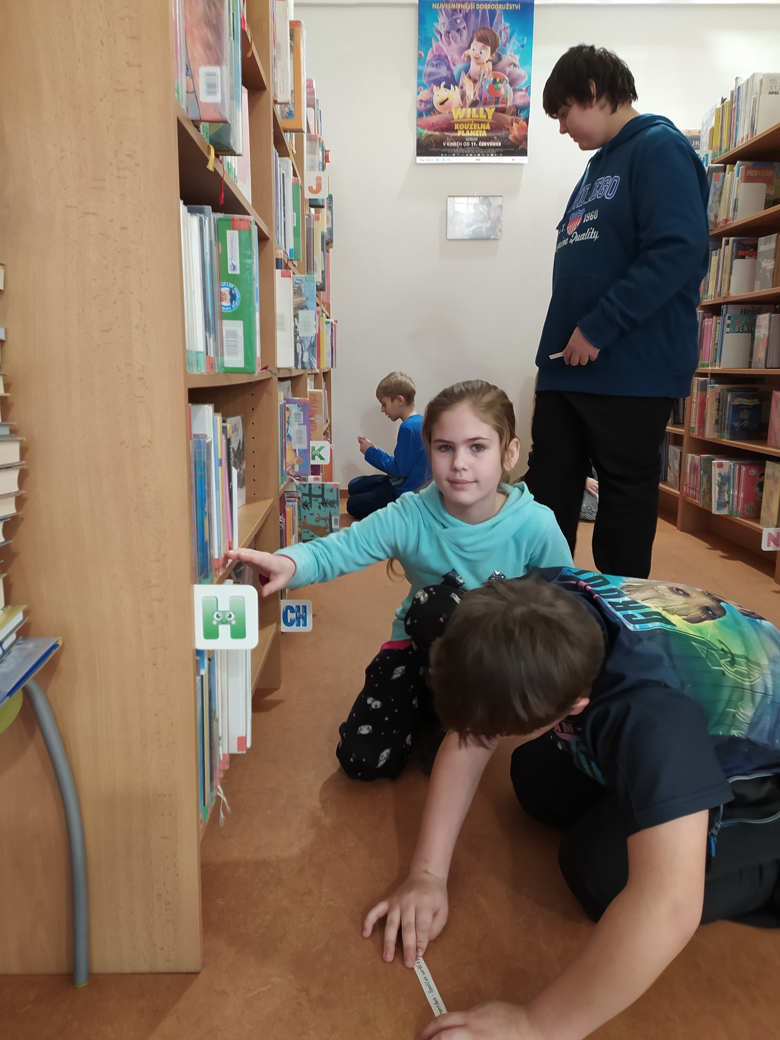 Expedice knihovna
Dva dny před pololetními prázdninami se žáci 4. B vydali po delší době na průzkum uničovské městské knihovny. A velice se jim dařilo.
Dozvěděli se, jak vypadá největší i nejmenší kniha na světě, kolik stran má nejtěžší knížka z knihovny a co jsou to "kolibříci". S paní knihovnicí odhalili tajemství barevných štítků na knihách a potom hbitě vyhledávali knihy podle názvu autora. Znalost abecedy ušetří spoustu času. Ti nejlepší objevitelé zvládli během čtvrthodiny najít kolem 10 knih!
Obliba pohádkových příběhů ustupuje, do odpočinkového patra si žáci vybrali většinou literaturu naučnou či dobrodružnou. A tak není divu, že by se mnozí pro rozečtenou knihu rádi vrátili jako právoplatní členové knihovny.
Přeji dětem, aby na ně kouzlo prostředí knihovny i samotných publikací působilo co nejdéle, aby díky němu poznaly spoustu zajímavých příběhů, informací a třeba i nových kamarádů.
A kdyby to nevyšlo? Nevadí. I vracení knihy je zábava! Zvláště když k návratu výpůjčky využijete venkovní box a knížku odešlete po kolejničkách do šuplíku... Pozor na hřbet!
Mgr. Hana Stachová, třídní učitelka