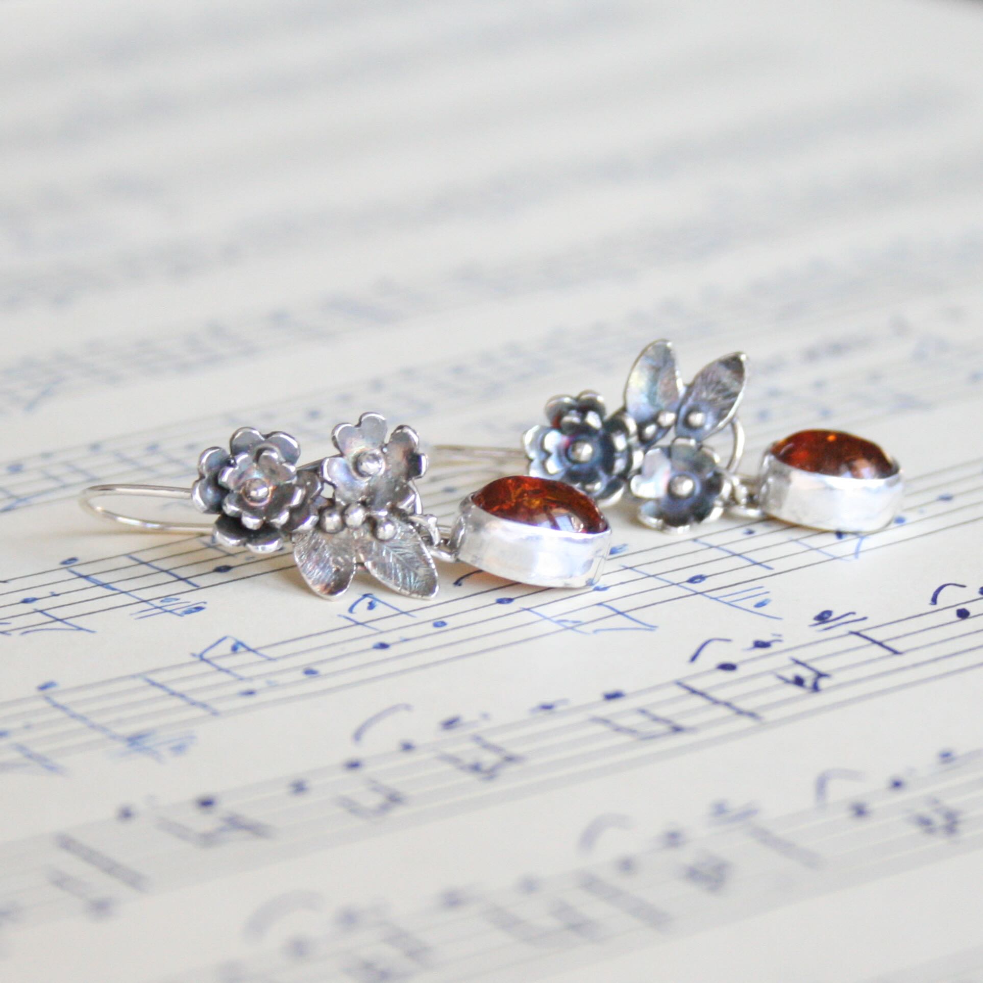 I've been spending time this week going over my pricing due to the cost of silver sky rocketing and unfortunately my prices are going to have to go up. It's not fun so I thought that I would share these earrings with you as they do make me happy :)
I love:
♥ the cluster of flowers
♥ the gorgeous warm colour of the amber
♥ the way the ear wire connects to secure the earrings
♥ the way the light shines through the amber
♥ and the way in which the amber gemstone can move when being worn 💕