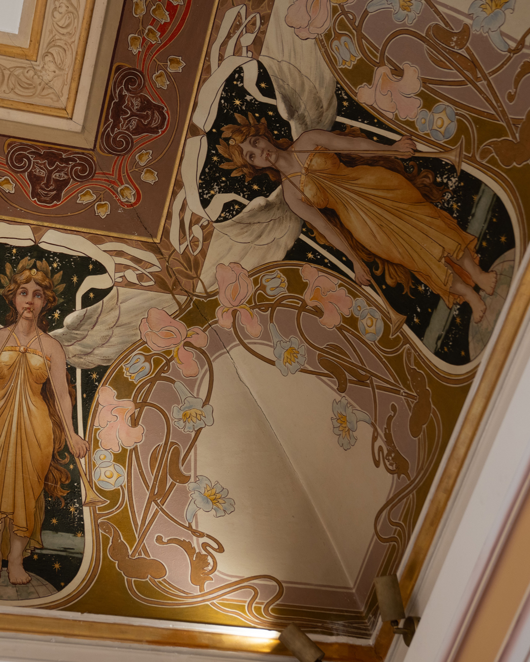 Look up. No, further up. There, curving across the ceiling of one of our restaurant rooms, is a fragment that most people miss entirely: the original Liberty Style cornice from what was once the Peacock Room.
Carlo Sada, the architect who designed Palazzo Parisio, created this space as one of Malta's earliest expressions of Liberty Style - Italy's answer to Art Nouveau. Giacomo Olzai brought Sada's vision to life with slender winged figures and organic forms that flow like water, their delicate lines still tracing the memory of peacocks across a starlit sky. Only pieces survive now, along with a single historic photograph, but they're enough to let you imagine the room as it was - all that fluid, expressive beauty filling the space.
The best part? You can admire it over dinner. Book a table at Luna, order something delicious, and spend the evening with your head tilted back, discovering details you'd never noticed before.
#FoodieFinds #restaurantsmalta #PalazzoParisio #PalaceLife #visitpalazzoparisio #palazzoparisionaxxar #palazzoparisiomalta #visitthepalace