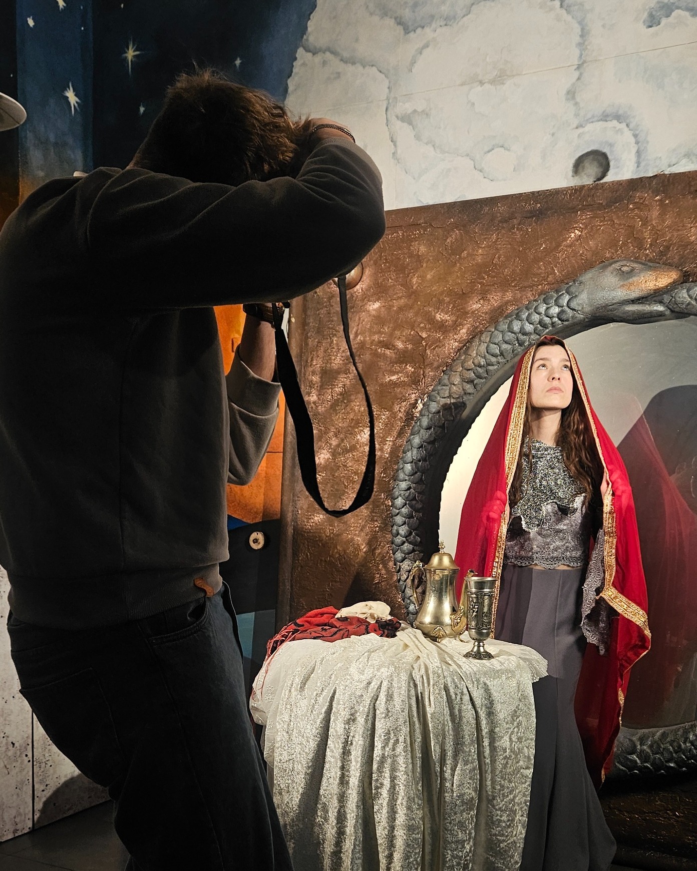 Na pierwszym zdjęciu widzicie Mieszka przy pracy. Na drugim - kadr, który z tej pracy powstał.
Naszą inspiracją było renesansowe malarstwo alegoryczne. Przyglądaliśmy się temu, w jaki sposób dawni mistrzowie opowiadali o upływie czasu, chorobie i śmierci za pomocą rekwizytów, gestów, światła i sposobu ustawienia postaci. Alegoria była językiem obrazu – symbolem, który pozwalał mówić o sprawach trudnych bez dosłowności. Zastanawialiśmy się, jak dziś można używać podobnych środków. Jakimi przedmiotami, jaką materią, jakim spojrzeniem zbudować znaczenie, które nie będzie ilustracją, ale opowieścią.
Mieszko Haładyn @haladyn_mieszko, absolwent Liceum Sztuk Plastycznych im. S. I. Witkiewicza w Słupsku, pracował z nami nad tym wizualnym dialogiem z Renesansem. W swoich fotografiach łączy techniczną precyzję z wyczuciem światła i kompozycji, budując kadry, które mają własny rytm i własne napięcie. To kolejny nasz wspólny projekt. Mieszko dokumentował wystawę przy „Pomorze. Ciemnej jutrzni” i współtworzył sesję promocyjną do albumu „Utopielisko. Piosenki zatopione”. W „Pomorze. Pustki w domu moim” jego zdjęcia stały się fundamentem dalszych działań wizualnych.
Każdy obraz zaczyna się od uważnego patrzenia. A potem od decyzji, co z tego spojrzenia ma zostać w kadrze.
Przedsięwzięcie „Pomór. Pustki w domu moim - laboratorium cyfrowego Renesansu” realizowane jest przez Fundację Materia Prima przy wsparciu Krajowego Planu Odbudowy i Zwiększania Odporności (KPO dla Kultury). Projekt sfinansowano ze środków Unii Europejskiej - NextGenerationEU oraz ze środków Miasta Słupska. Naszym Mecenasem jest również Scania Polska S. A.
#NextGenerationEU #KPOdlakultury
@miastoslupsk_official @slupski_osrodek_kultury @teatrlalkitecza @scaniapolska @nimitpolska @kultura_gov_pl @fundacjamateriaprima