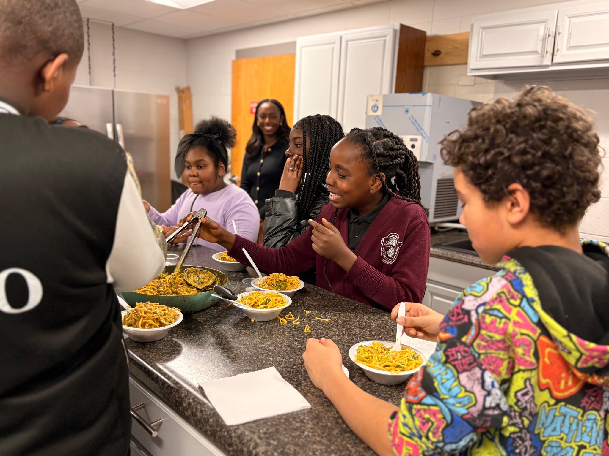 Every Thursday, New Gen students ride the bus to Powhatan Community Center to attend cooking classes with award winning chef and entrepreneur @victoria_inspires of @victoriaskitchenrva.
As they chopped vegetables, peeled garlic, and cut chicken breasts, Ms. Victoria offered easy-to-remember advice about hosting, cooking for family, and kitchen safety, along with a dash of science to explain the chemistry of cooking. With her warmth and steady guidance, it's no wonder Ms. Victoria has been nominated as one of the 2026 @remarkablewomennxst !
Students maneuvered around, passing bowls and spices or tagging in to stir the pots or clean counter tops. They not only appeared competent and confident in the kitchen--they were having fun!
The payoff came when they gathered to share their meal: a creamy chicken alfredo with a delicious kick of spice. One student announced, "This is the first time I've ever eaten broccoli."
See more photos on flickr: https://flic.kr/s/aHBqjCKXCq