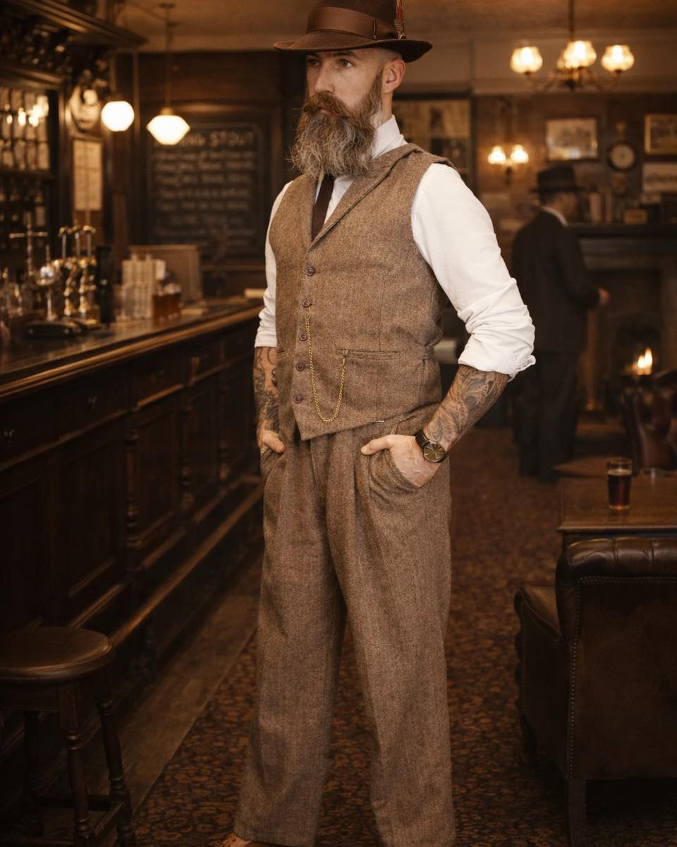 A long week of hard labour deserves its reward.
The tools are set aside, the noise of the workshop fades, and the evening finds its place in the warm light of a proper pub. A moment to stand tall, take a breath, and enjoy the quiet satisfaction of a week well spent.
Dressed for the occasion in The Bramble trousers and The Thistle waistcoat, both cut from the same brown and beige herringbone wool blend, the look carries the character of honest work and timeless British style. Topped off with The Hargrove Fedora, it is a combination that feels just as at home by the bar as it does on the streets outside.
Because a gentleman who works hard during the week deserves to relax in proper style.
The Bramble
The Thistle
The Hargrove Fedora
The Nilwik Clothing Co.
#gentlemanstyle #heritage #heritagestyle #heritageinspired #heritagewear #gentlemanswardrobe #vintagestyling #waistcoats #harringbone #fedorahat #fishtailtrousers #1920s #1920sstyle #peakyblindersstyle #workingclass #workingclassman #upperclassstyle #nilwikclothing #peakyblindersimmortalman #theimmortalman
