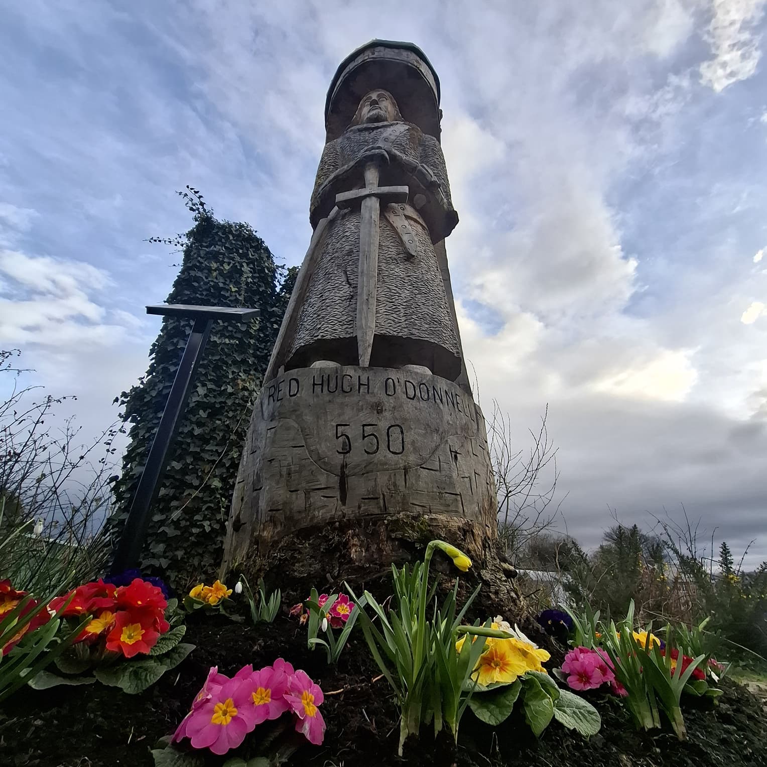 A Chieftain Reclaimed from the Wood 🌳⚔️
In the heart of Donegal Town, history has a way of emerging from the landscape itself. This striking figure isn't just a statue; it is Red Hugh O’Donnell, the "Fighting Prince of Donegal," brought back to life by artist Gintas Poderys.
The choice of medium is as poetic as the history it represents. Carved from a single, native Irish beech tree, the sculpture feels like it grew directly out of the soil Red Hugh once fought to protect.
Who was Red Hugh? He was the last great hope of Gaelic Ireland. At just 15, he was kidnapped by the English and imprisoned in Dublin Castle to keep his powerful family in check. His daring escape through the snowy Wicklow Mountains on Christmas Eve is the stuff of legends—fleeing barefoot through the ice, losing his toes to frostbite, but never his resolve.
He returned to Donegal to lead the Great Irish Clans in the Nine Years' War. Though he eventually died in exile in Spain, his spirit never truly left these shores.
Next time you pass through Donegal Town, take a moment to look into the grain of the beechwood. You aren't just looking at a carving; you’re looking at the soul of the North West.
Do you have a favorite figure from Irish history? Share their story below. 👇
#RedHughODonnell #DonegalHistory #IrishHeritage #GintasPoderys #WildAtlanticWay #GaelicIreland #DonegalTown #IrishArt #WoodSculpture