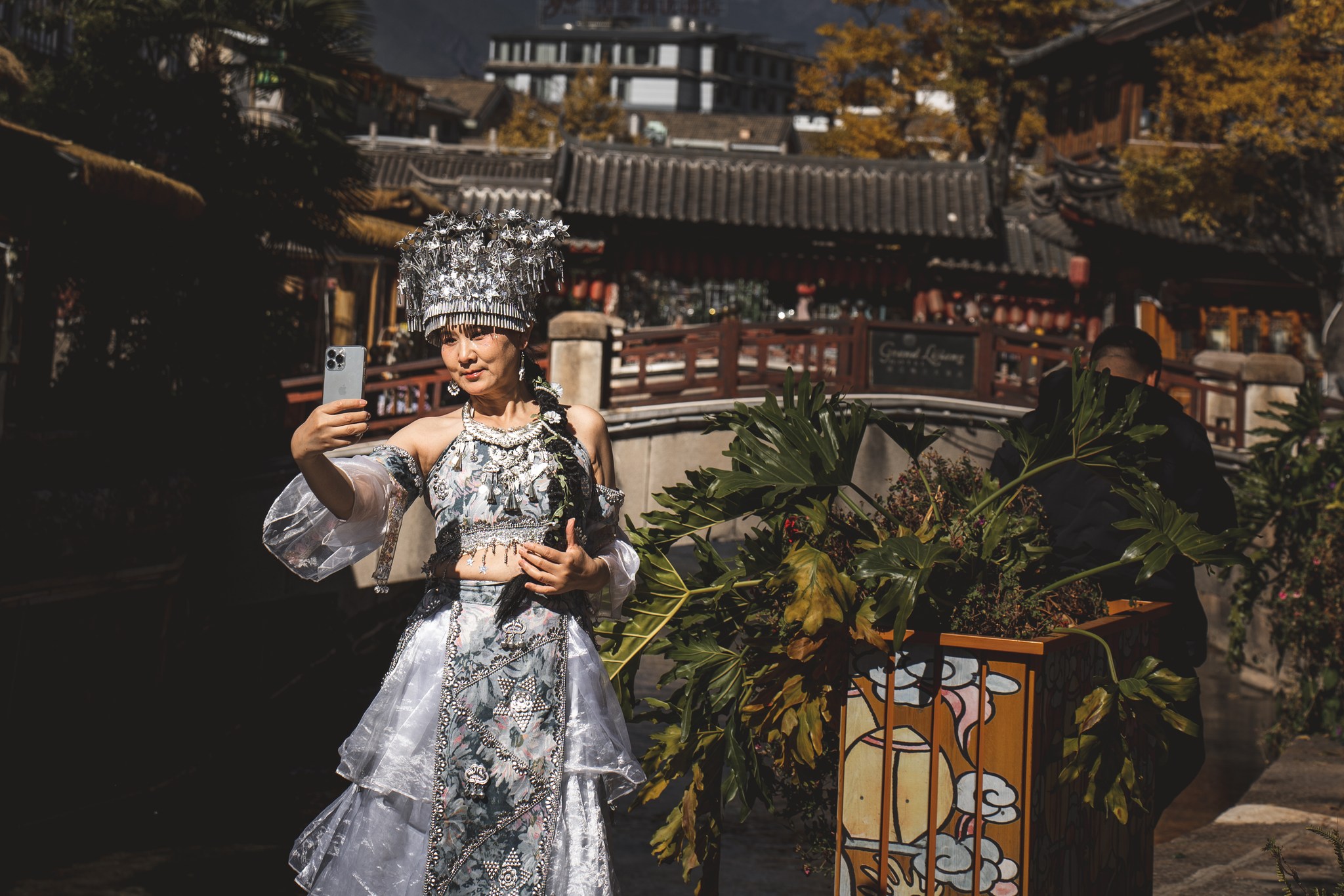 Nord du Yunnan — le verso de la carte postale
Ici, l’effacement ne fait pas de bruit. Il ne détruit pas frontalement — il remplace, il recouvre, il rejoue.
Du sud au nord du Yunnan, les anciennes villes sont réécrites. Les façades se reconstruisent, les rues se scénarisent et vendent les mêmes objets, les mêmes images, les mêmes récits simplifiés. On conserve les formes, on efface les vies. On garde l’image, on perd le sens dans un rouleau compresseur qui transforme les traditions en décors et les cultures en produits.
À Shangri-La, en territoire tibétain, à plus de 3000 mètres d’altitude, cette logique devient presque irréelle, dystopique. Des foules de touristes chinois arrivent, masques à oxygène sur le visage, costumes tibétains sur le dos. Ils posent, moulins à prières à la main et agneaux sur les genoux devant des stupas reconstruits.
Ça pourrait être beau, pourtant j'ai envie de pleurer.
Car transformer une culture en attraction, ce n’est pas la célébrer. C’est la simplifier, l’aplatir, la vider de ses nuances, de son histoire, de sa profondeur. C’est la rendre consommable.
Ici, au Tibet, je vois une autre forme d’effacement que le musellement d'une culture. Un type d'effacement plus subtil et silencieux, plus insidieux.
Surexposer pour mieux faire disparaître.
On joue aux Tibétains sans eux. On réduit pour mieux vendre. Et à force de simplifier, la culture devient caricature.
Et le plus troublant ? Cette tristesse, cette lourdeur diffuse partout. Un parc d'attraction où on consomme pour faire semblant d'être heureux. Mais ça ne prend pas.
Alors je pédale. Je m'échappe par les routes les plus raides à la recherche de ce qu'il reste encore d'authentique.
👇 English in comment
