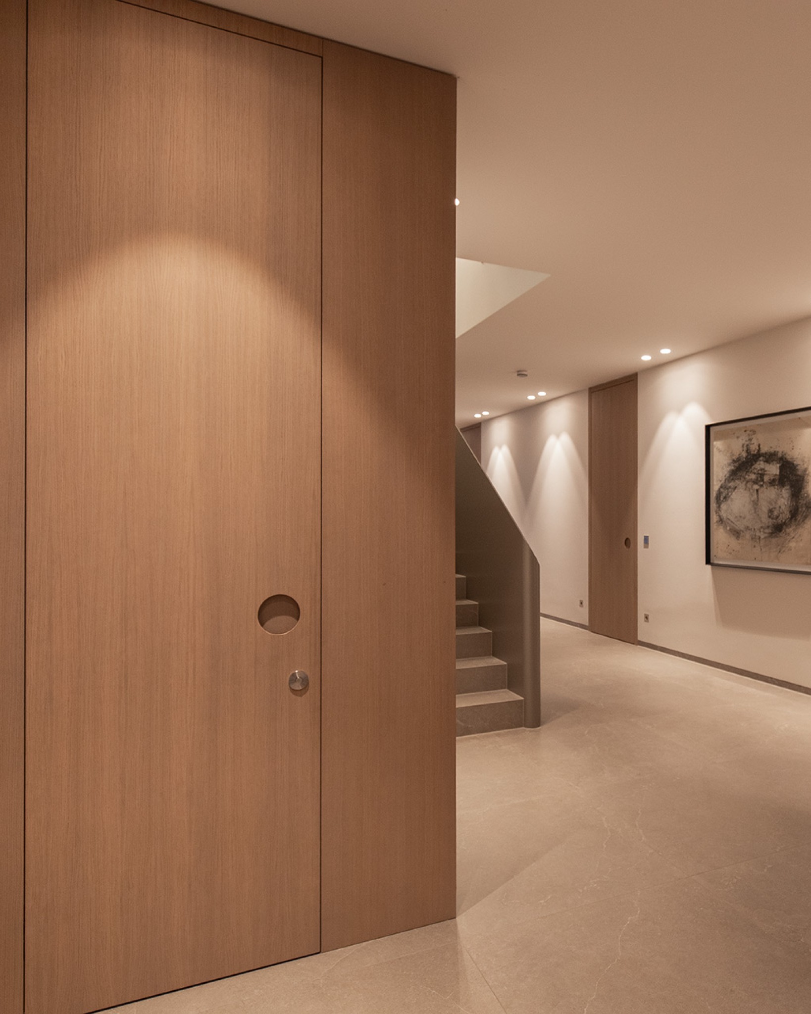 Diese maßgefertigten Türen aus heller Eiche ziehen sich durch den gesamten Wohnraum und reichen bis zur Decke – so entsteht ein Gefühl von Großzügigkeit und Ruhe.
Raumhoch, flächenbündig in die Wand eingearbeitet, mit unsichtbaren Bändern: Statt eines klassischen Schlosses kommt ein spezieller Magnetverschluss zum Einsatz. Auf eine Drückergarnitur wird bewusst verzichtet – stattdessen sorgen individuell angefertigte, runde Griffmulden aus Vollholz für eine puristische Optik.
Die Oberfläche wurde abschließend mit einem Naturholzeffektlack behandelt, um die natürliche Wirkung des Holzes noch stärker hervorzuheben.
#tueren #interieurdesign #tischlerhandwerk #holzhochzwei