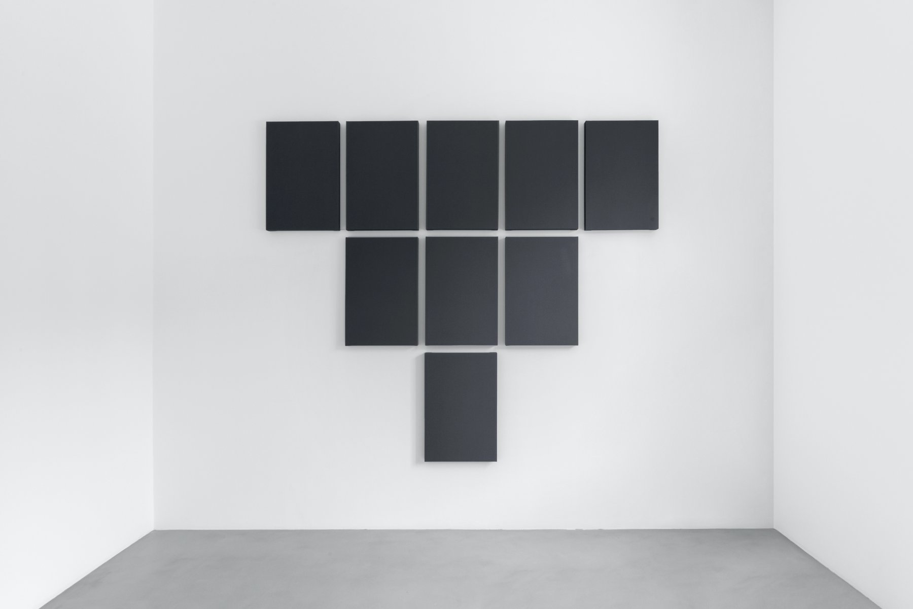 Born in 1948, Alan Charlton is a British painter whose work follows in the footsteps of the American minimalists of the 1960s. He currently lives and works in London. After a traditional academic career at art school, Alan Charlton definitively abandoned figurative art in the late 1960s. Since 1971, the artist has been producing gray monochromes, focusing his work on the careful composition of the elements that make up a painting as an object in itself. His austere, almost ascetic work is based on the negation of any narrative other than the creative process itself.
Charlton thus enumerates the possible operations on the form of a frame of constant thickness (4.5 cm) and emphasizes the space available for spreading the paint by completely covering the canvas stretched on the frame in a uniform manner without any roughness. To do this, the artist applies several successive layers to his canvases before sanding them. Through this process, Alan Charlton manages to highlight the volume and spatiality constituted by the object itself, which is the work of art, giving his work a sculptural dimension.
The different variations in frame used by the painter play on the tension that exists between the affirmation of one form and the negation of another: a tight sequence of canvases can be seen as the alignment of several works, or as the division of a single one. By dividing or reducing frames in ways that are simultaneously akin to multiplication or addition, the artist explores the formal interaction between his works and the exhibition space, the latter allowing, by contrast, for the affirmation or division that takes place in the visual space.
Similarly, the shades of gray used display the entire range between the effacement of near-white and the quasi-totemic affirmation of near-black, sometimes giving his work the characteristics of an ode to presence and absence. Gray is also chosen by the artist for its paradoxical dimension, evoking in turn the feeling of desolation associated with urban landscapes and meditative tranquility.
#alancharlton #minimalism #art #contemporaryart #monochrome