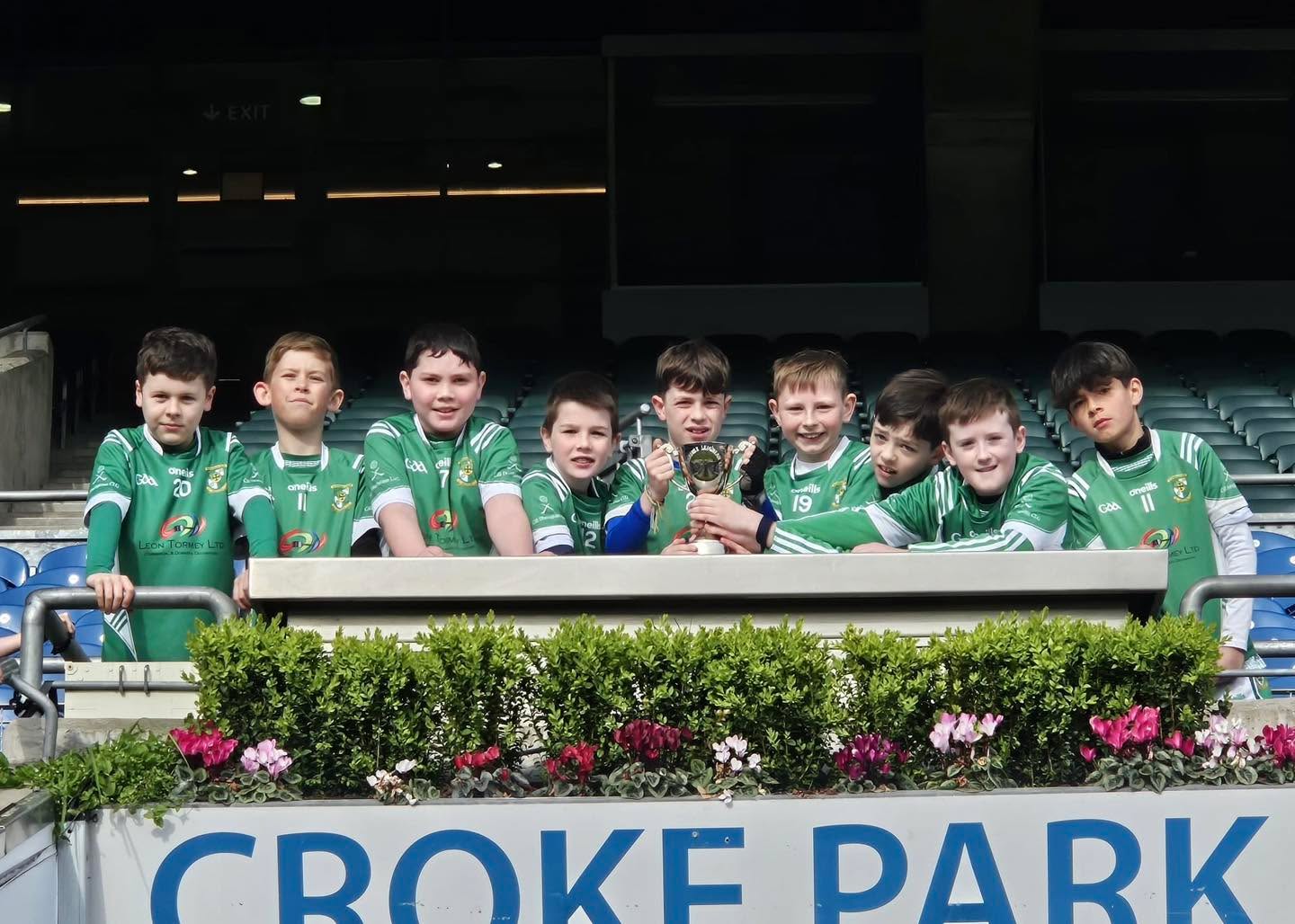 As part of the Leinster Council’s Play & Stay initiative, our U10 boys, along with their mentors and families, travelled by bus to Jones’ Road for a very special trip to Croke Park.
The day kicked off with a pitchside photo before the team enjoyed a behind-the-scenes tour of the dressing rooms and warm-up areas. The highlight followed soon after, as the lads proudly ran out through the tunnel of the Cusack Stand to take on Ballinteer St John’s in a series of hurling matches.
The boys were outstanding throughout, showing great skill, teamwork, and sportsmanship. They are a great credit to the club!
After the games, the lads had the experience of climbing the steps of the Hogan Stand to lift the cup!
Who knows — we may well see some of these lads back here in years to come wearing the green and gold of Meath.
The day wrapped up with school group photos before the team made the journey back up the M2, with a well-earned stop at Burger King to refuel.
Maith sibh a bhuachaillí! A brilliant day from start to finish!
If your child is interested in joining the team, please contact Padraig on 0872562965.