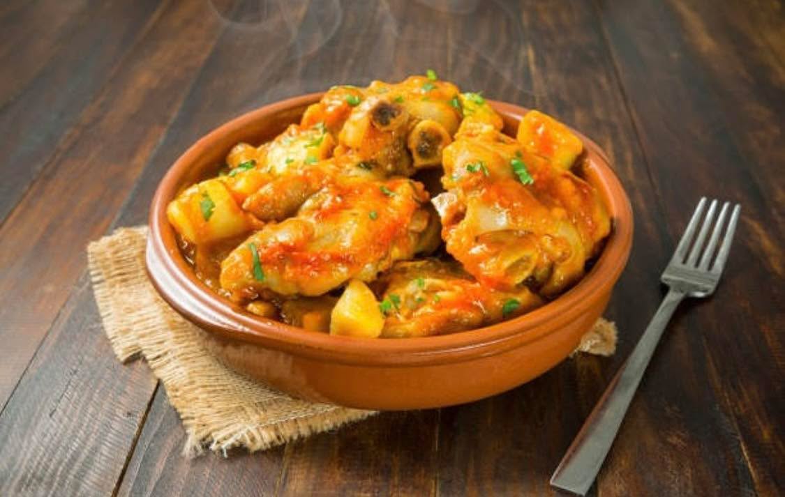 "Juicy pork knuckles slow-cooked in a rich, spicy tomato sauce with potatoes. Pure comfort in a bowl! 🍲