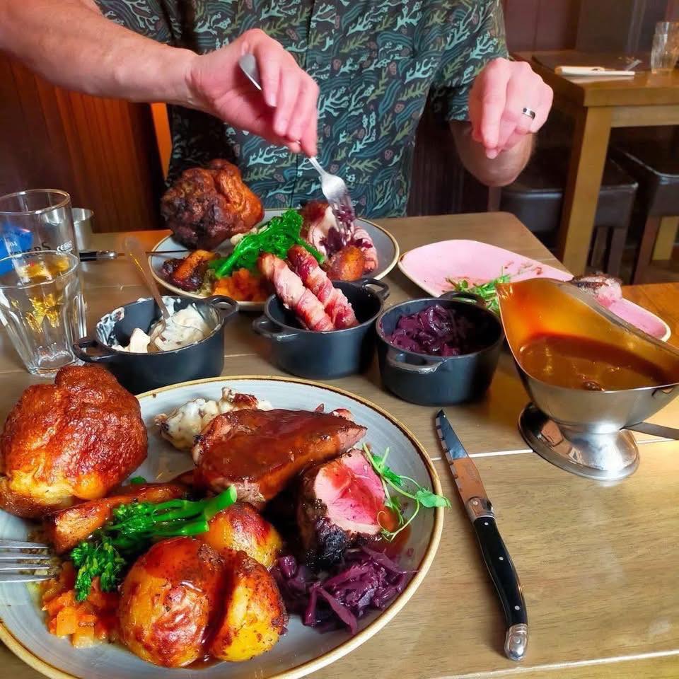 Roast Dinners at The Falcon Steakhouse
There’s no meal on our menu that gets more time, care, and love than our roast dinners—and judging by the feedback, our guests can taste the difference.
So, what sets our roast apart from the rest? For starters, we don’t use pre-cooked joints. At The Falcon, your roast comes with actual steak—top-quality meat cooked fresh to your preference. It’s a roast dinner, elevated.
Our roast potatoes are crisped in beef tallow infused with garlic, thyme, and rosemary—rich, golden, and bursting with flavour. And the gravy? It’s based on our house beef dripping sauce, the same one we serve with our steaks. We might be biased, but it could just be the best gravy in the world.
For those who want it all, we’ve created The Sunday Best—a sharing feast for two. You’ll get all three meats: tender sirloin, juicy lamb rump, and a French-trimmed chicken breast wrapped in bacon. It comes loaded with all the trimmings—cauliflower cheese, pigs in blankets, heaps of seasonal veg, giant Yorkshire puddings, and unlimited gravy. To finish, choose any two homemade desserts from our pudding list.
You can also upgrade the Sirloin to succulent Ribeye or tender Fillet!
Sure, there are cheaper roasts out there—but we’re confident there aren’t many better. We’ve got tables available this Sunday, and we’d love to show you what all the fuss is about.
https://www.falconsteakhouse.com/book-now/