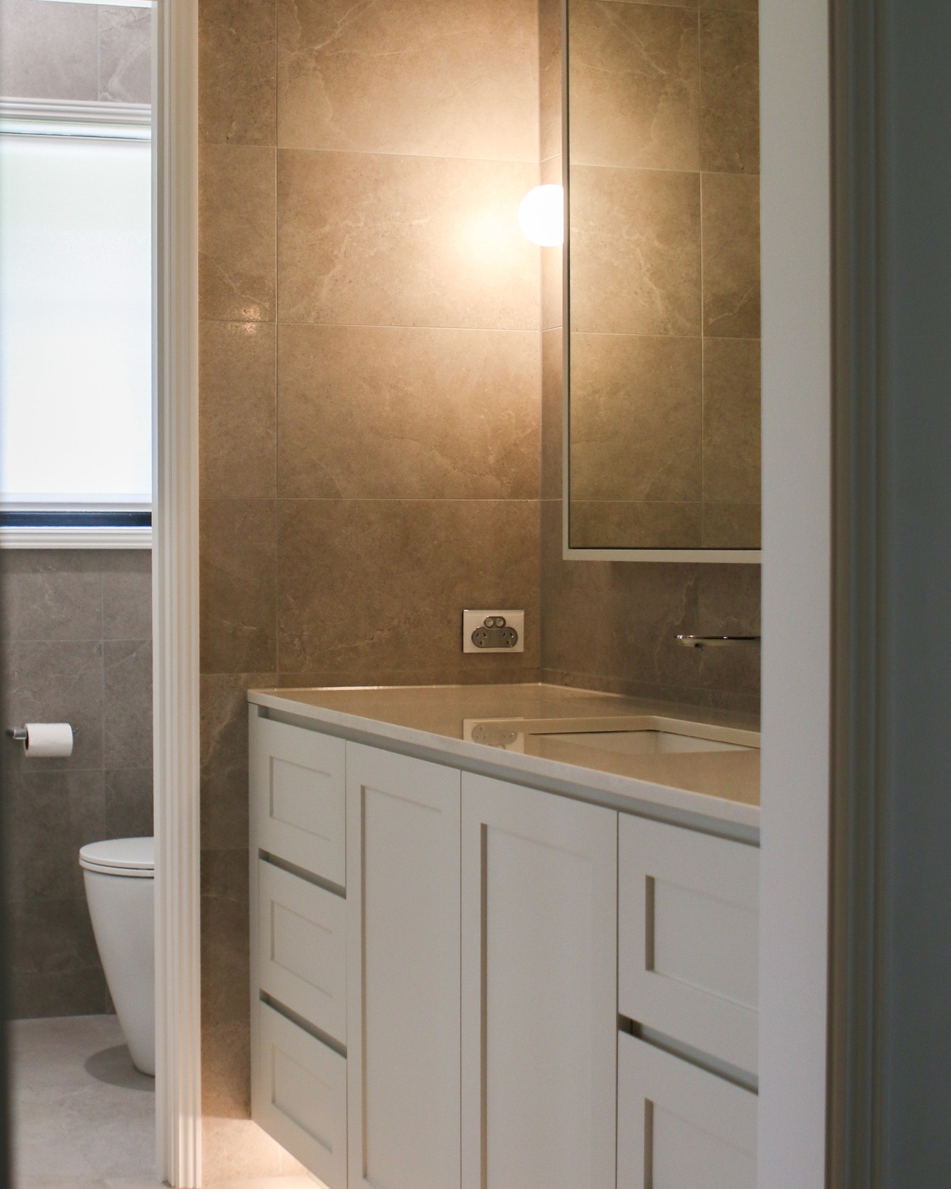 Characterised by refinement, this Main bathroom presents a sophisticated aesthetic with shaker-style doors in a satin polyurethane finish, enhanced by soft lighting that cultivates a peaceful environment.