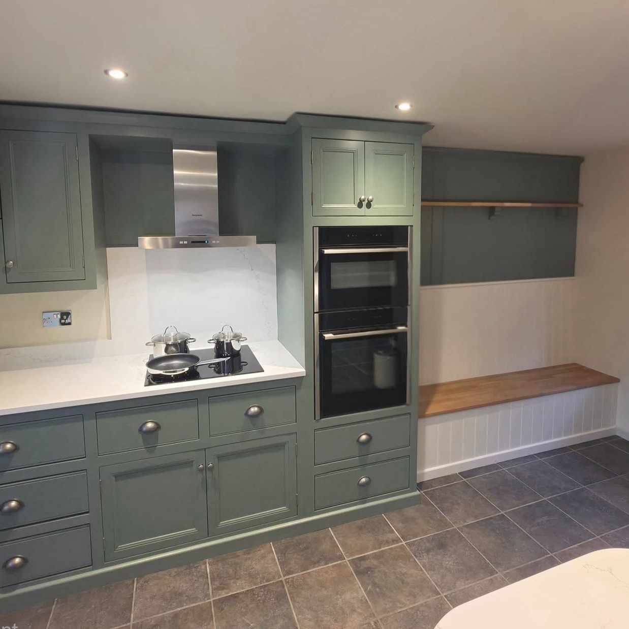 A truly bespoke kitchen, handcrafted and hand-painted in situ to create a finish that’s as unique as the home it sits in. The result is a kitchen that feels both refreshed and completely bespoke.
A standout feature is the built-in seating area – perfect for relaxed dining, socialising, or making the most of everyday moments at home. The movable island on wheels adds real versatility, giving extra worktop space when needed and the option to open up the room, with secure locking to keep it firmly in place.
Finished with light quartz worktops and practical eye-level ovens, the design not only enhances functionality but also brightens the entire space, creating a clean, open, and welcoming feel.
A perfect blend of smart design and timeless style.
Well done and thank you to Jim and Lee for fitting, Sam for plastering, Lee and Ed for electrics, and Dave for hand painting the units.
#HandPaintedKitchen #BespokeDesign #KitchenTransformation #QuartzWorktops #ModernKitchen #goodwinskbb #kitchendesign
www.goodwinskbb.co.uk