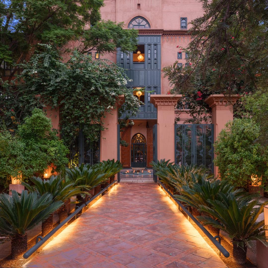 As daylight fades, the riad transforms.
Paths softly illuminated, gardens deepening in color, and architecture revealed through shadows and warm light. Each space becomes more intimate, more intentional, inviting you to slow down and experience it differently.
Dinner settles under the palms, reflections dance on the water, and every corner feels suspended between stillness and life.
This is where the day gently turns into night. And the atmosphere becomes everything.
#riadliving #marrakechnights #moroccanluxury #gardendining #slowtravel #luxuryescape #marrakechstyle