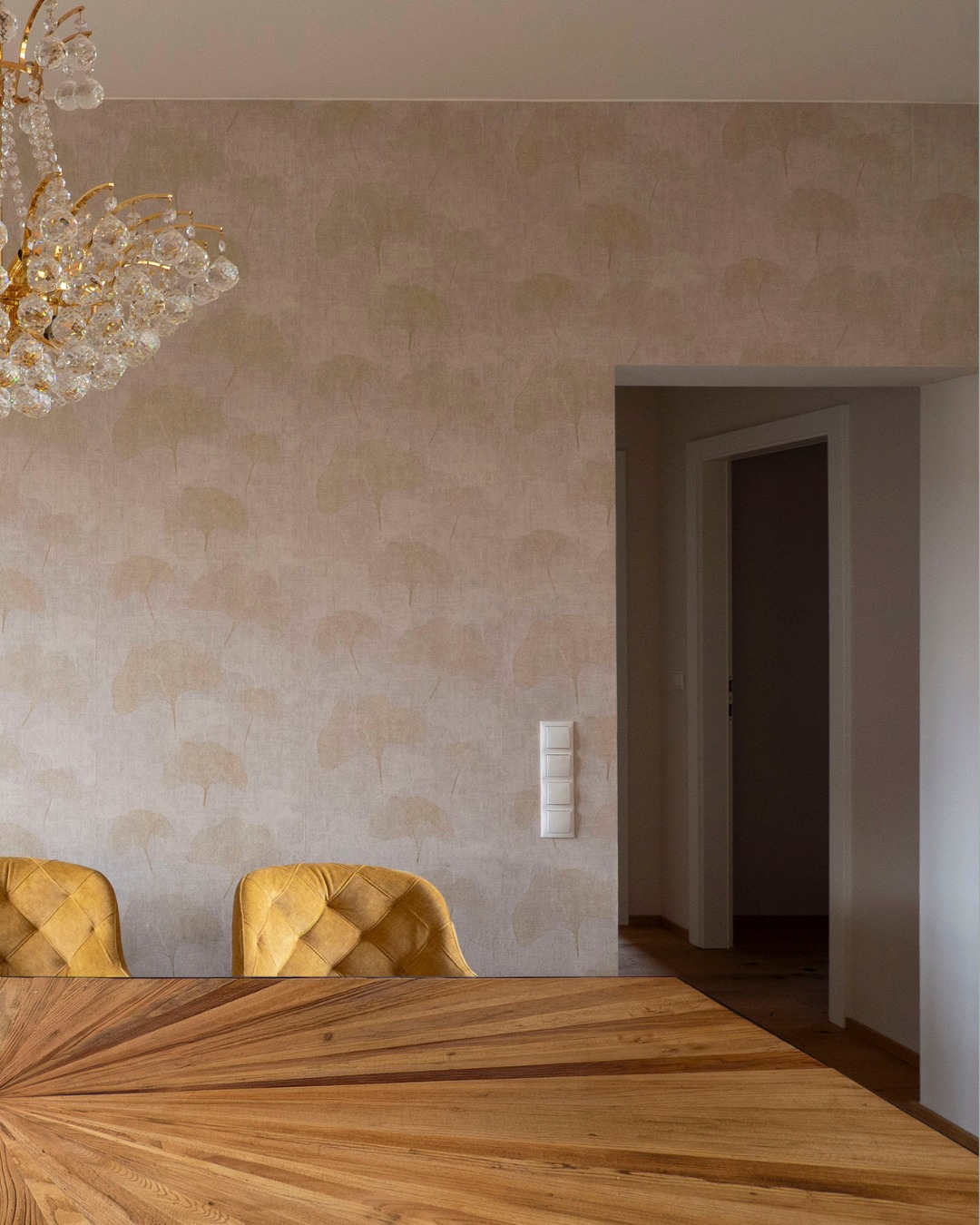 Details, die Charakter verleihen. ✨
Die Struktur des Holztisches korrespondiert perfekt mit den feinen Mustern der gewählten Tapeten. Auch hier haben wir das „Alte“ geehrt: Der bestehende Kronleuchter findet in der modernen, hellen Umgebung einen neuen, würdigen Platz. Es sind diese Besonderheiten, die ein Zuhause persönlich machen.