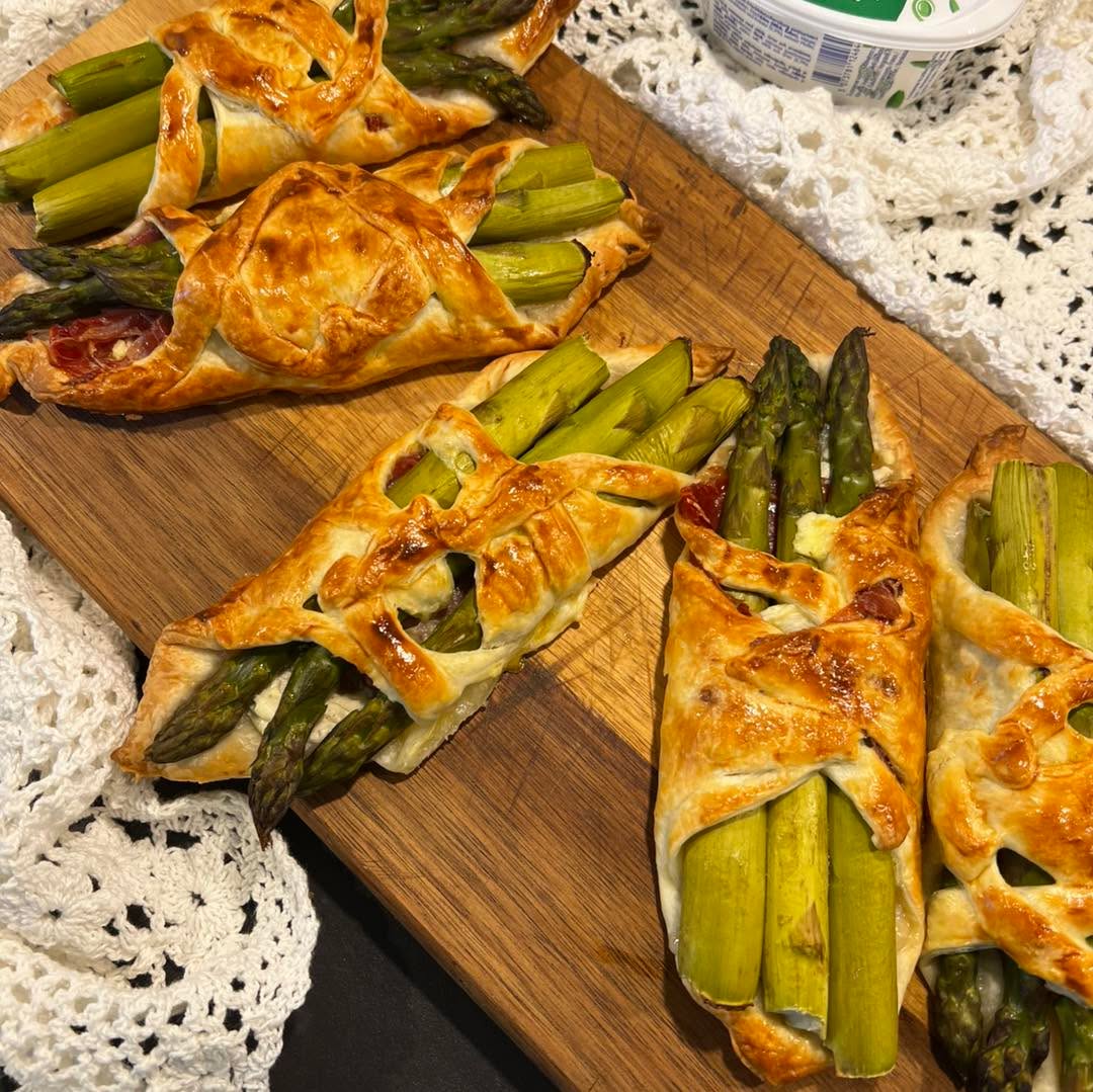 Spargel-Rohschinken Päckli
Knuspriger Blätterteig, cremiger Frischkäse, zarter Rohschinken und frischer Spargel – dieses Rezept verbindet einfache Zutaten zu einem richtig feinen Genuss.
Perfekt als Apero, leichtes Abendessen oder für Gäste. Schnell vorbereitet und aus dem Ofen einfach unwiderstehlich.
Zutaten für 6 Portionen:
1 Blätterteig, Rechteckig
500 g grüner Spargel
150 g Rohschinken
150 g Frischkäse (Cantadou mit Knoblauch + Kräuter)
Salz, Pfeffer
1 Ei
Zubereitung:
Den Backofen auf 210°C Ober-/Unterhitze vorheizen.
Den Spargel waschen, die hölzernen Enden abschneiden - für ca. 2-5 Minuten blanchieren und abtropfen lassen.
Den Blätterteig auf einem Backblech ausrollen und in ca. 6-8 gleich grosse Rechtecke schneiden.
Jedes Rechteck jeweils bei 2 gegenüberliegende Ecken L-förmig parallel zum Rand einschneiden.
Die Rechtecke mit dem Frischkäse bestreichen und den Rohschinken darauf verteilen.
Je 2-3 Spargelstangen darauf legen, mit Salz und Pfeffer würzen.
Die Teigecken abwechselnd über die Füllung klappen und festdrücken.
Das Eigelb verquirlen und den Teig damit bestreichen.
Im vorgeheizten Ofen für ca. 15-20 Minuten goldbraun backen.
Die Päckchen servieren und geniessen.
#thekitchenwitches #spargeln #feinschmecker #leckeressen #easyrecipesathome #leckerundgesund #frischgekocht
