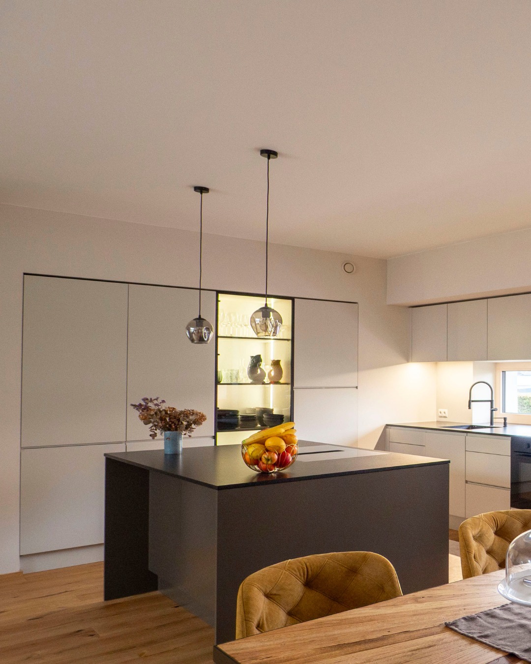 Das Herzstück des Hauses: Eine offene Wohnküche, die Großzügigkeit neu definiert. 🍽️✨
Durch die vollständige Neuplanung der Raumwege haben wir Platz für eine imposante Kochinsel und einen großen Esstisch geschaffen. Besonders stolz sind wir auf den Mix: Während die Küche in modernem Greige und klaren Linien besticht, thront über dem Esstisch ein prachtvoller Kronleuchter aus dem Bestand.