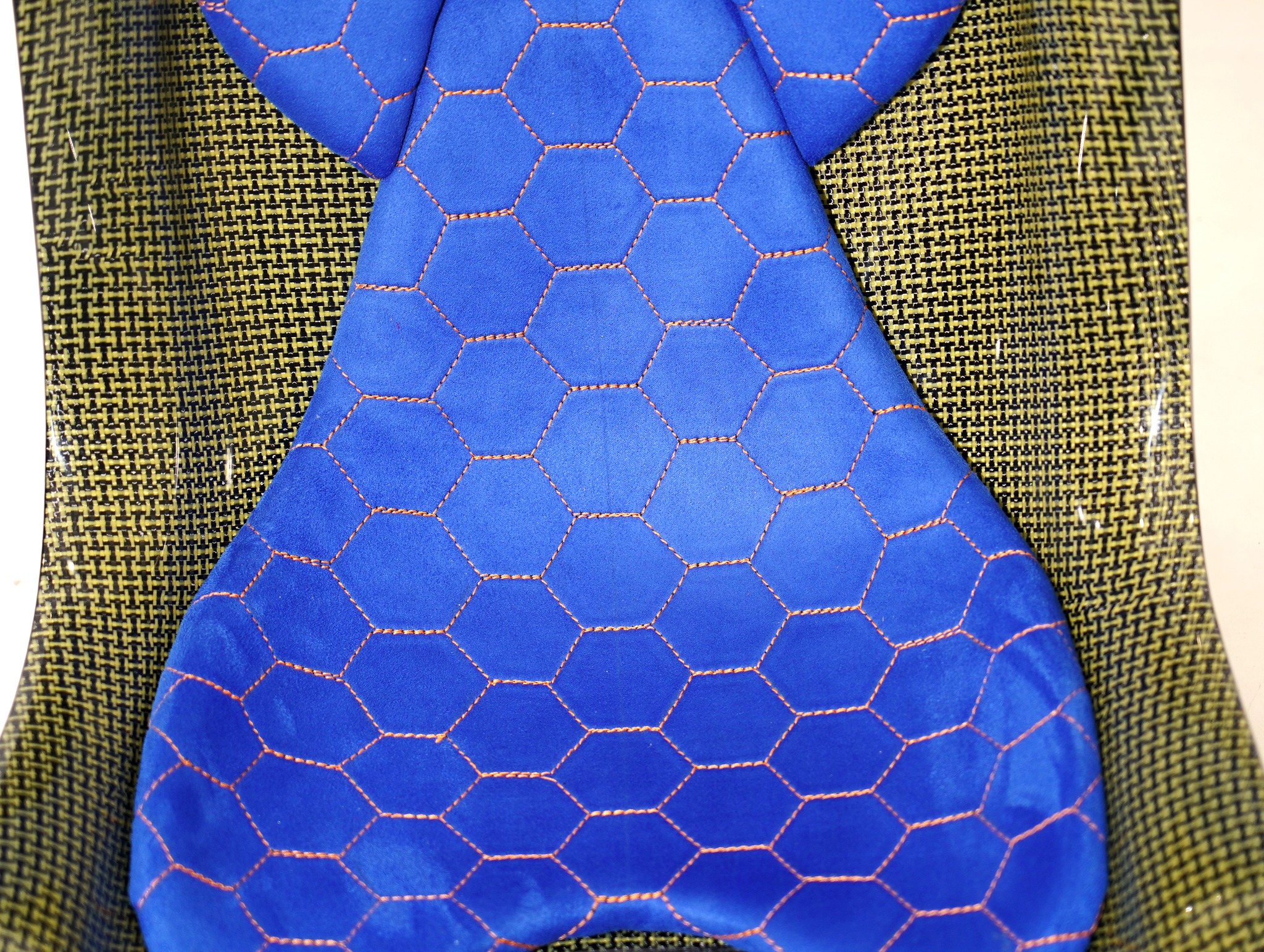 KevMannz yellow Kevlar bucket seats V3, featuring custom blue Alcantara padding with yellow honeycomb stitching pattern and empowering logo embroidery on headrest padding - where every drive becomes a journey of limitless possibility.