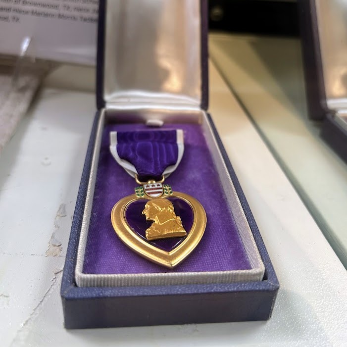Today, on National Purple Heart Day, we pause to honor the extraordinary courage and sacrifice of the men and women who were wounded or gave their lives in service to our nation.
Here at the Brown County Museum of History, we are privileged to preserve the stories of six Purple Heart recipients whose service and sacrifice are forever woven into the history of our community:
Sgt. Elman Adair Anderson, USMC – Killed in Action, World War II
Cpl. Willard A. Perry Jr., USA – Killed in Action, Vietnam
SSgt. James "Jamie" W. Fisher, USAF – Missing in Action, World War II
PM1 Robert Glenn Smith, USN – Missing in Action, World War II
Louis Alexander Kirksey Jr., USA – Wounded in World War II and returned home to Brown County
Sgt. Lewis Benjamin Goins, USA – Killed in Action, World War II
Their stories remind us that freedom has always come at a tremendous cost. Whether they made the ultimate sacrifice, were declared missing in action, or returned home bearing the wounds of war, each demonstrated remarkable bravery and an unwavering commitment to serving others.
Today, we remember these six heroes, along with every Purple Heart recipient throughout our nation's history. May we never forget their sacrifice or the legacy they leave behind.
#NationalPurpleHeartDay #PurpleHeart #HonorTheirService #BrownCountyMuseum #BrownwoodTX #RememberTheirSacrifice