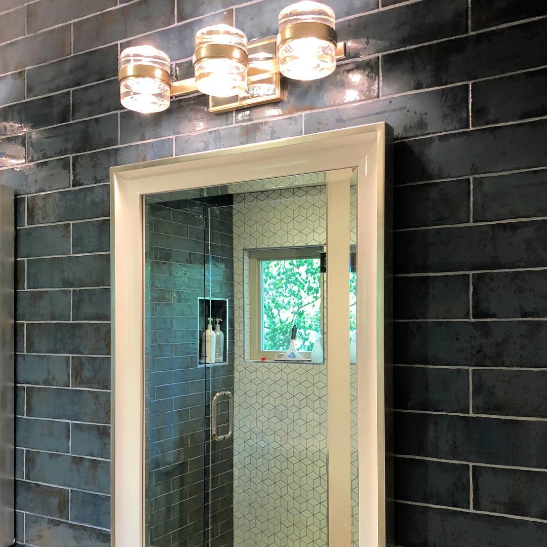 iPhone snap of the master bathroom in the New Orleans inspired remodel. That tile 🙌. Every detail was considered...the white mirror frame ties in with the geometric shower tile...the silver leaf on the light fixtures and mirrors...the aged brick look of the wall tile. #austininteriordesign #interiordesign #customdesign #itsinthedetails #custombathroom #masterbathroom