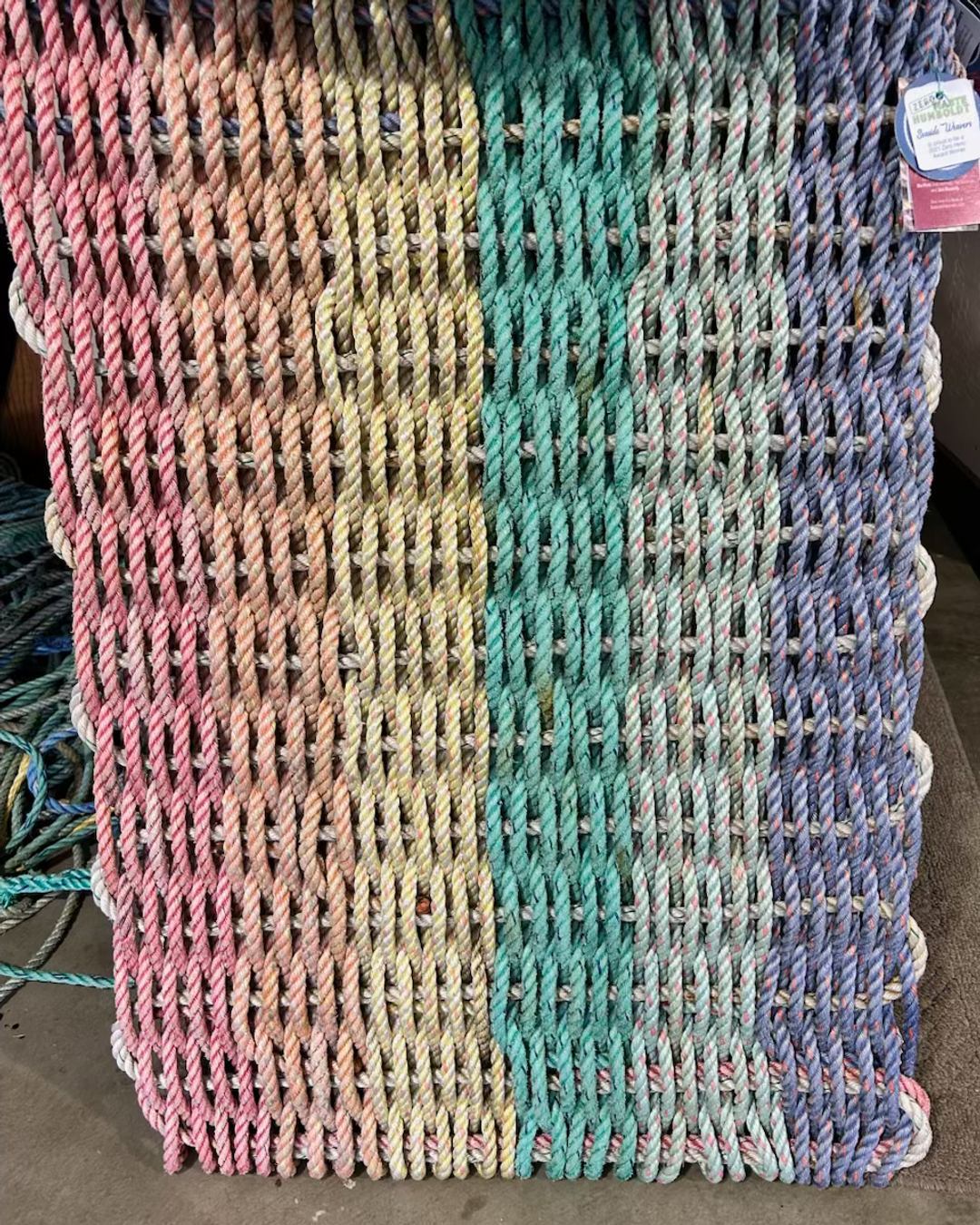 Brighten your doorstep with The Rare Rainbow MerMat🌈 Handwoven from reclaimed crab pot rope, it’s more than just a doormat; it's a story, a piece of art! Only 10 available, don't wait! Link in Bio #EcoFriendly #HomeDecor #SeasideWeavers