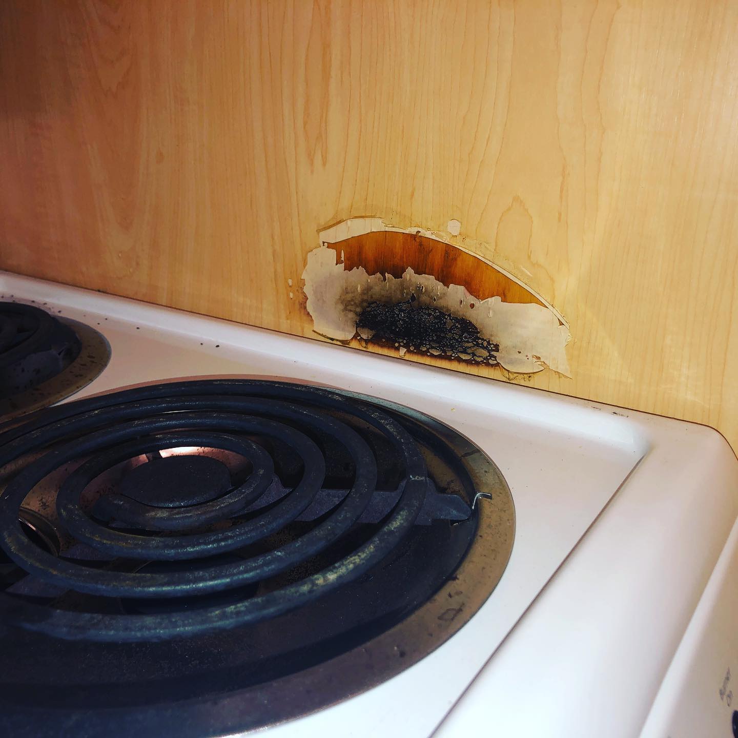Wood burning stove?! Side wall next to burners are combustible. Typically you will see a small countertop/cabinet space between range and cabinet or a side wall with non combustible materials like sheet metal or tile.